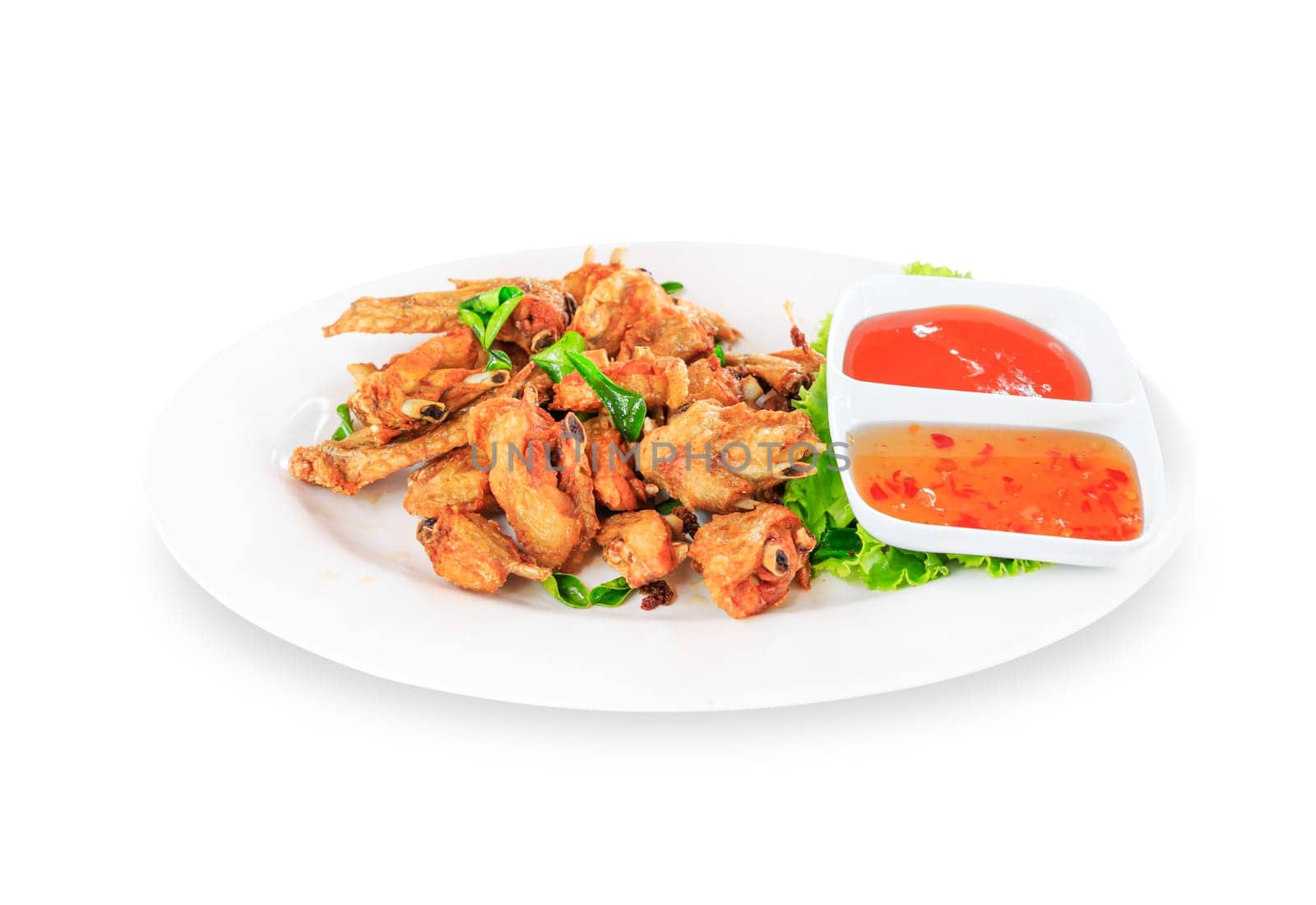 Fried chicken wings with sauce in white plate on white background