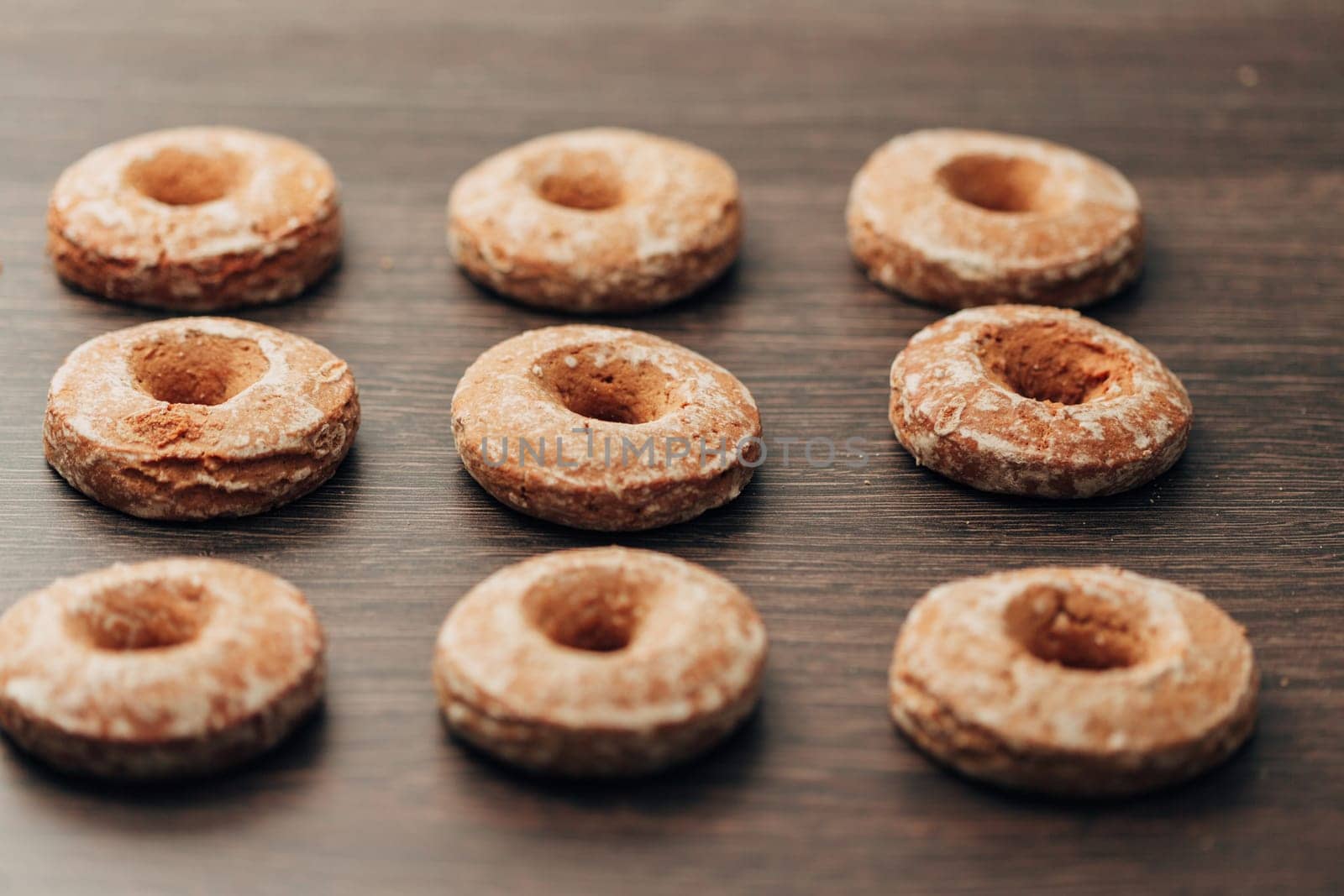 Beautiful Many Bagels and Gingerbreads Lie on a Brown Background