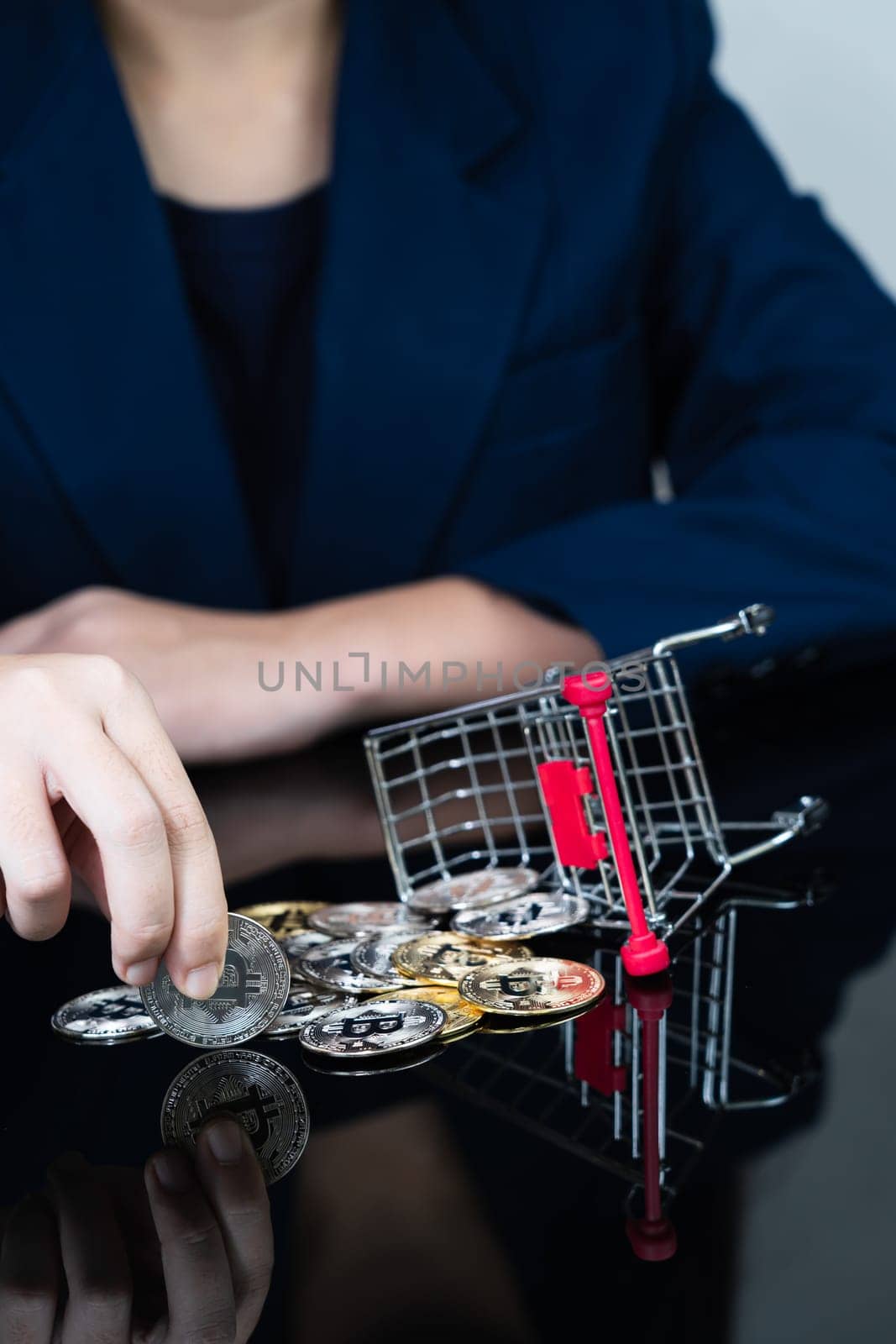 Close up of business woman holding some pieces of golden Bitcoin token in shopping cart, Bitcoin is one of the popular cryptocurrency