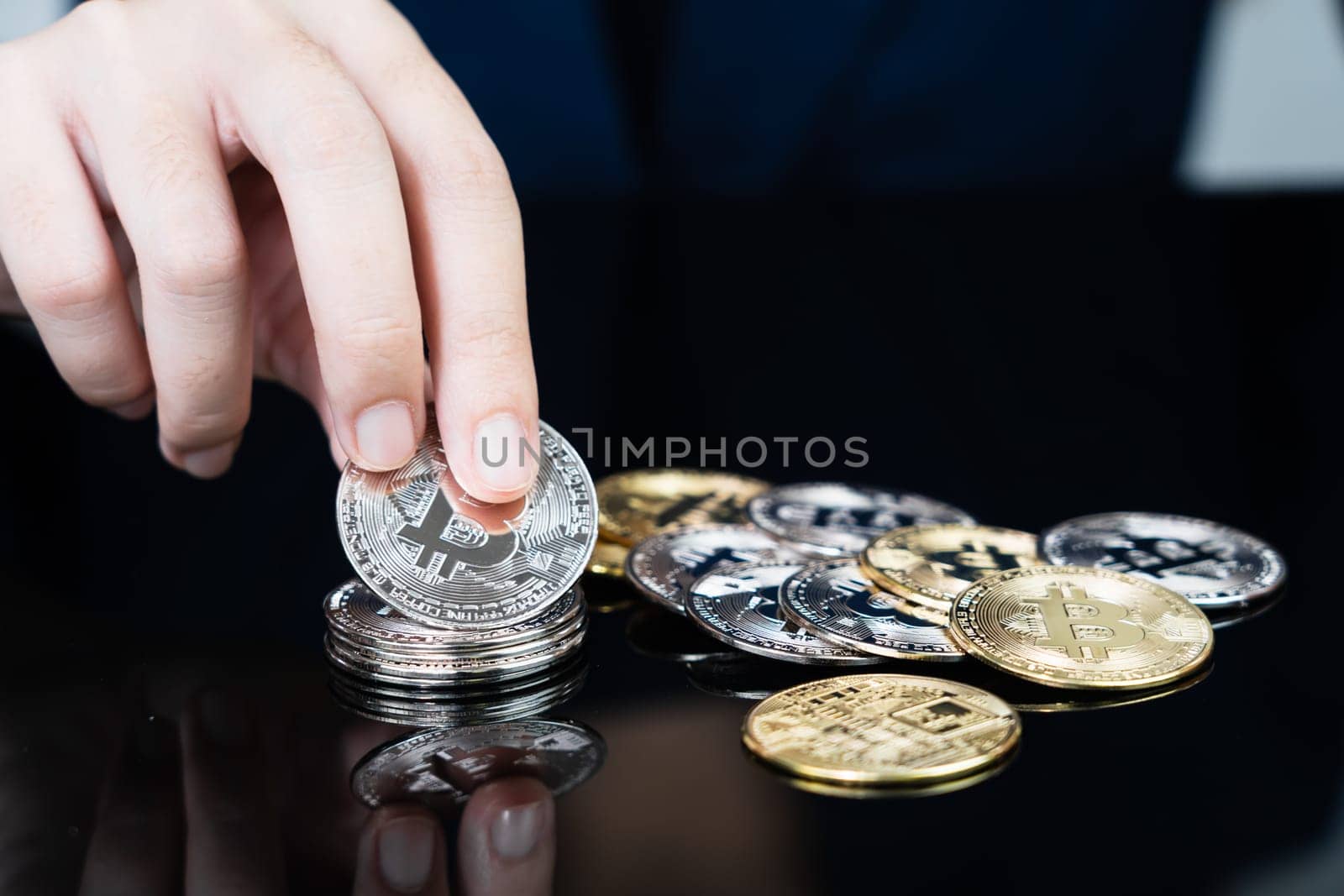 Close up of business woman holding some pieces of golden Bitcoin token , Bitcoin is one of the popular cryptocurrency