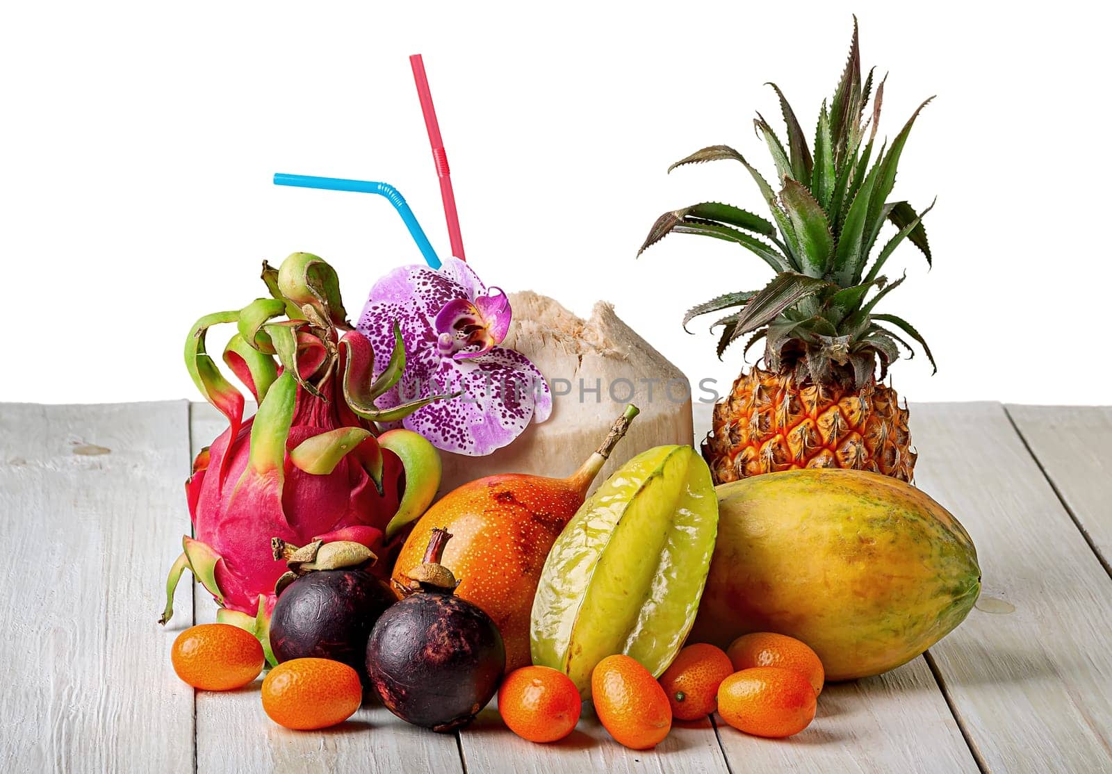 Tropical fruits on wooden table top view isolated on white background