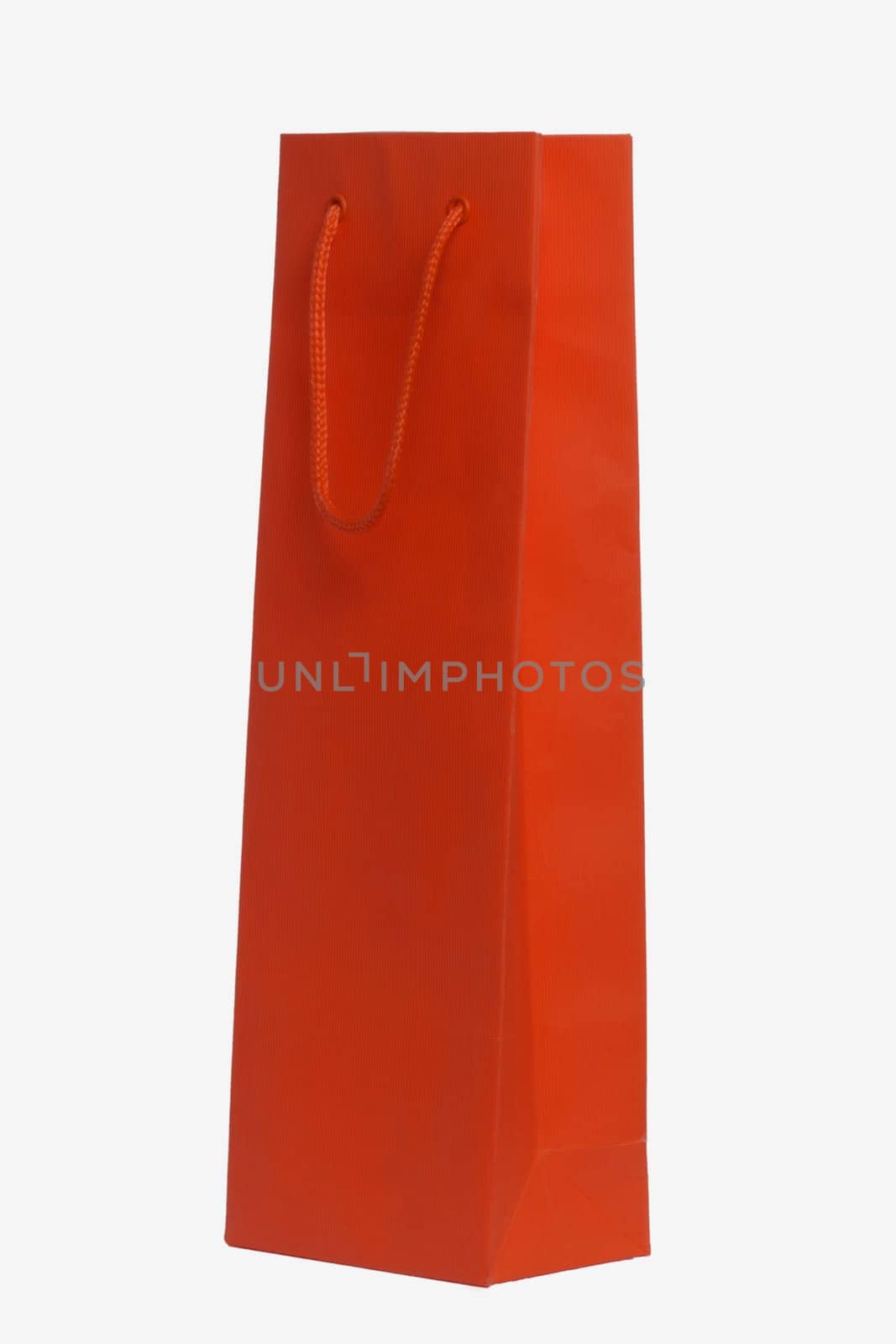 Closeup of a single red paper bag or pouch with red handle for shopping or for gifts isolated on a white background. Macro photograph.