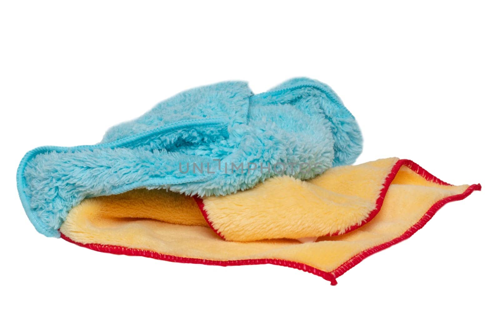 Household cleanliness and hygiene. Close-up of a blue and a yellow cleaning cloth isolated on a white background. Microfiber cleaning cloth. Macro.