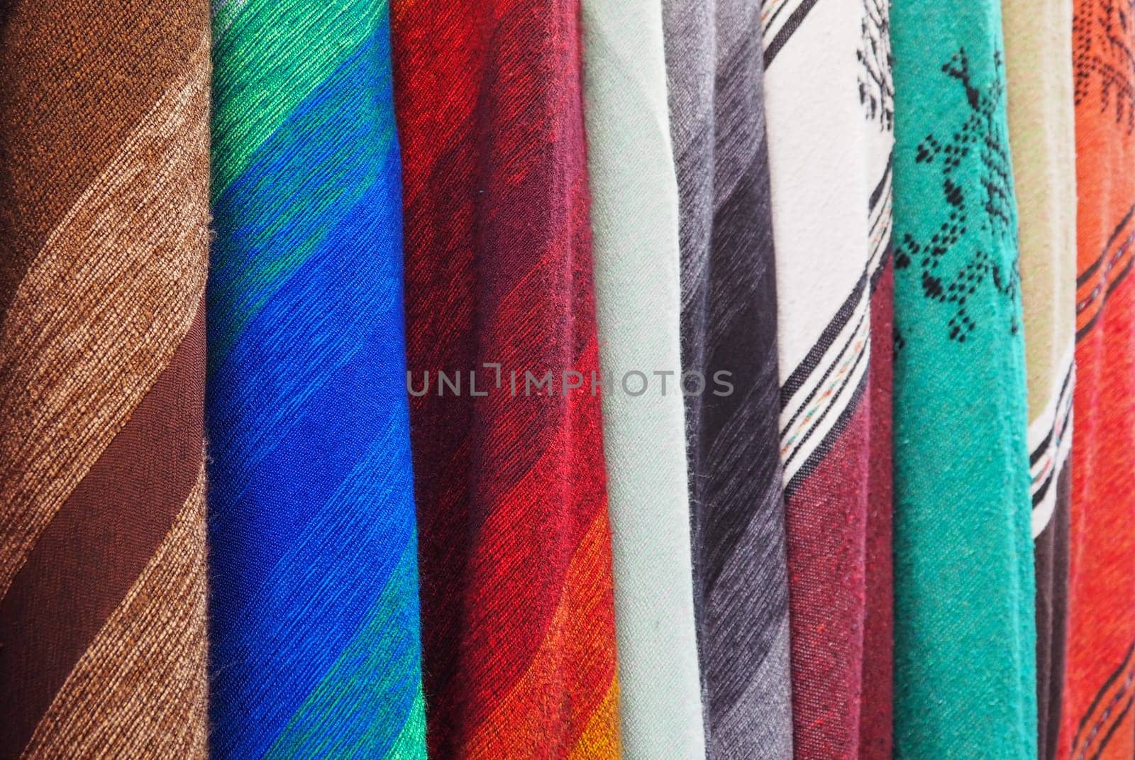 Colourful textile scarfs or blankets displayed on street market in Fes, Morocco - closeup detail.