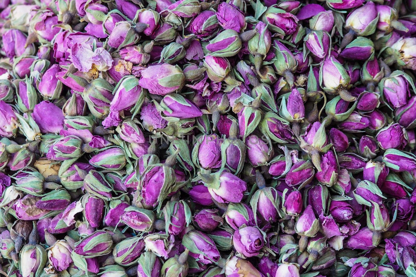 Pile of dried rose flowers used as natural fragrances displayed on souk - traditional street market in Morocco.