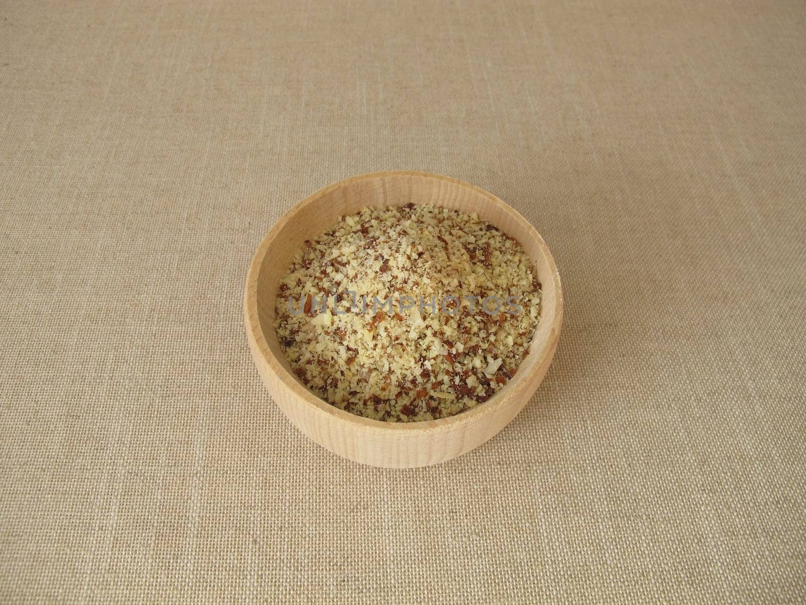 Unpeeled ground almonds in a wooden bowl