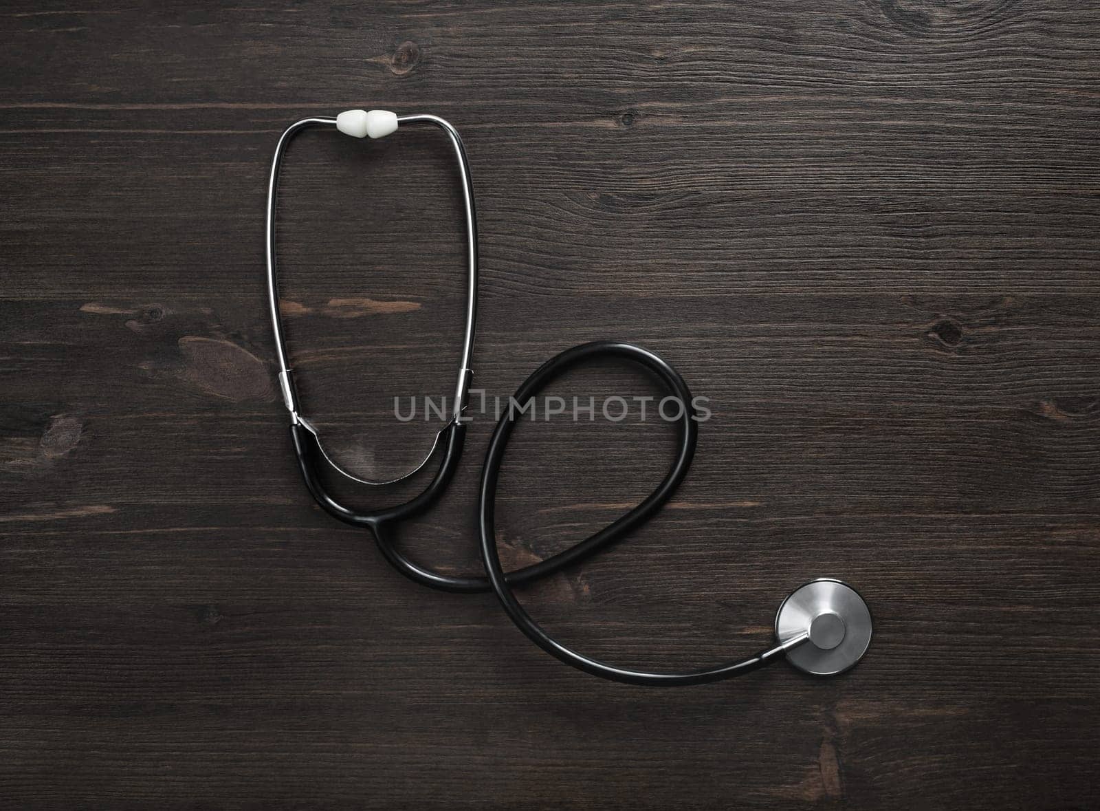 Medical stethoscope on wood table background. Flat lay.