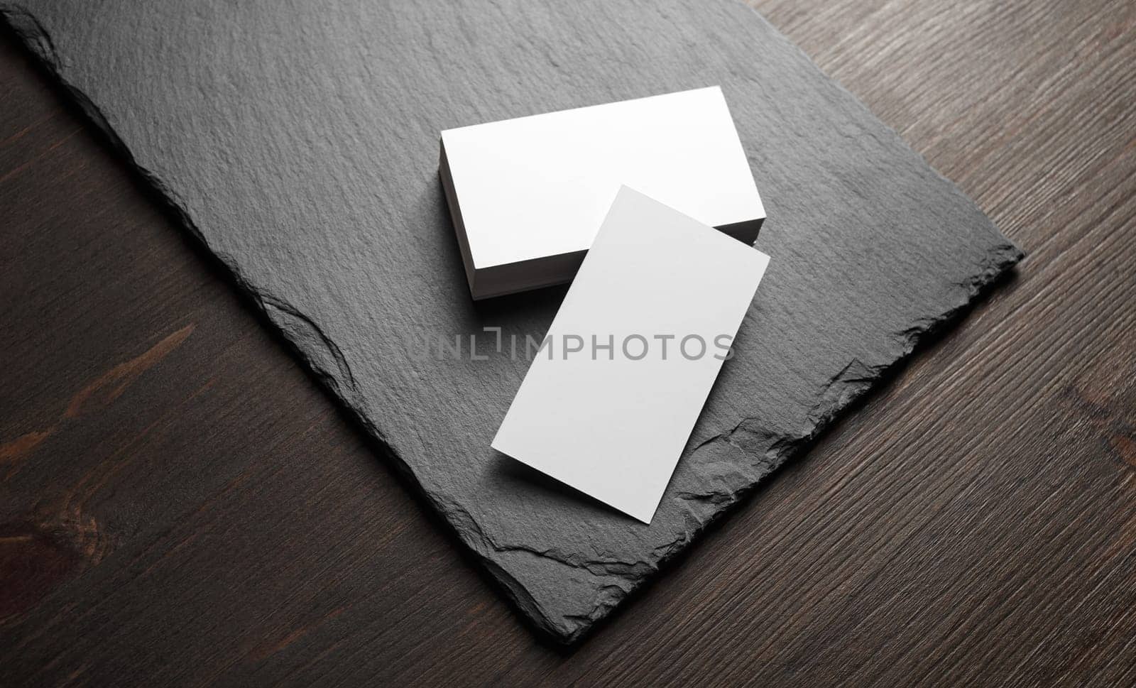 Photo of blank business cards on stone board background. Template for ID.