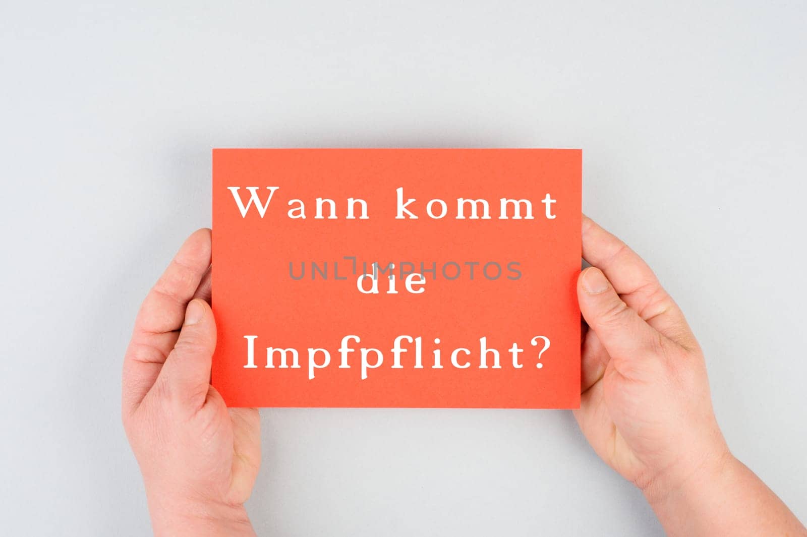 When does the mandatory vaccination comes is standing in german language on the red colored paper, covid-19
