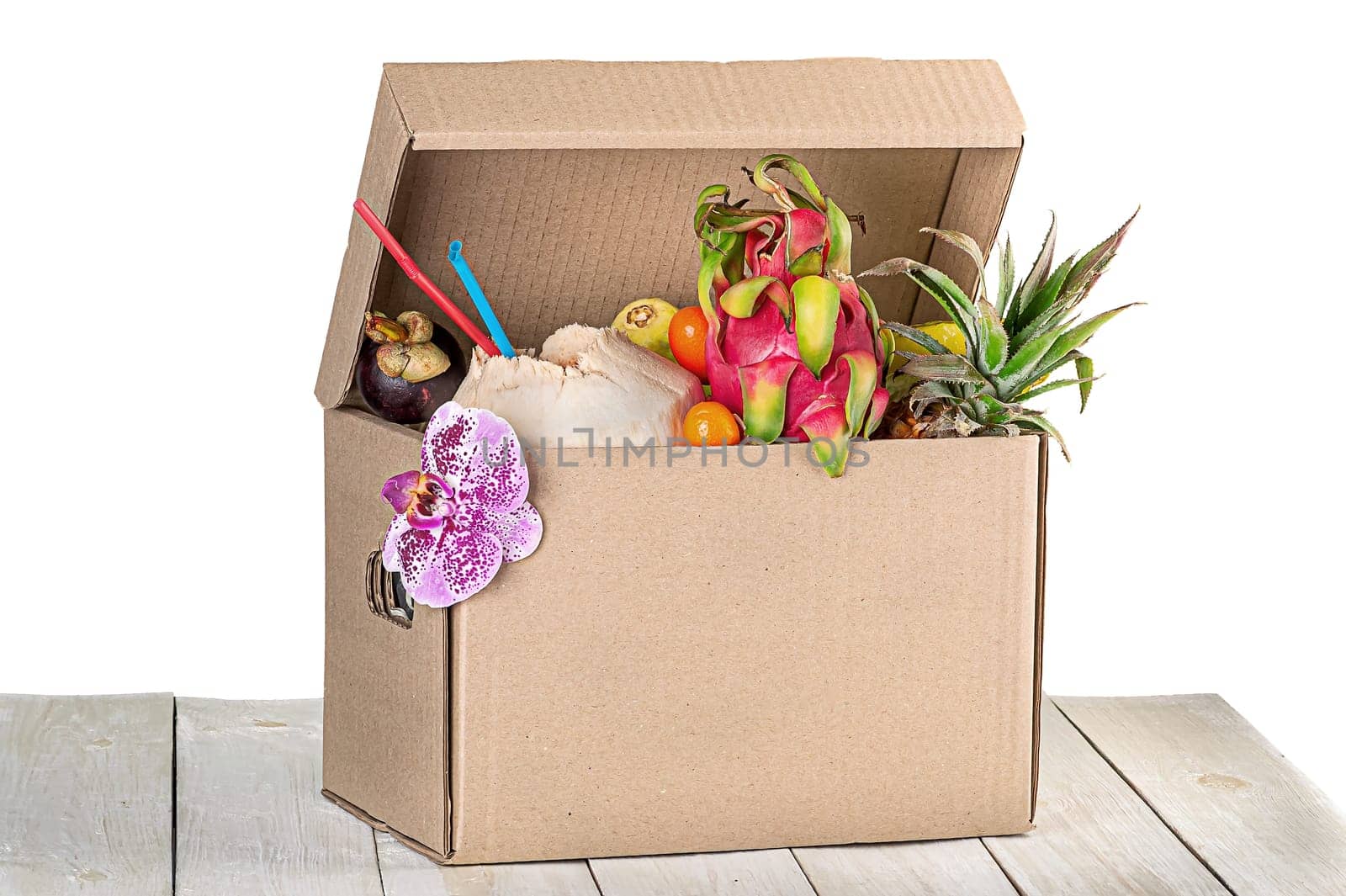 Tropical fruits in cardboard box isolated on white background