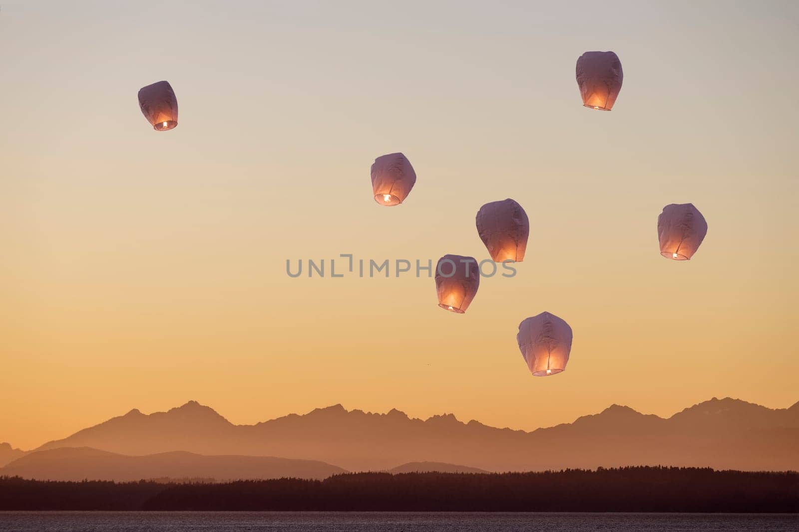 A group of flying lanterns being released into the nightsky.