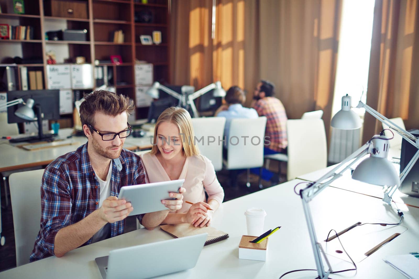 Two successful co-workers with touchpad preparing presentation in office