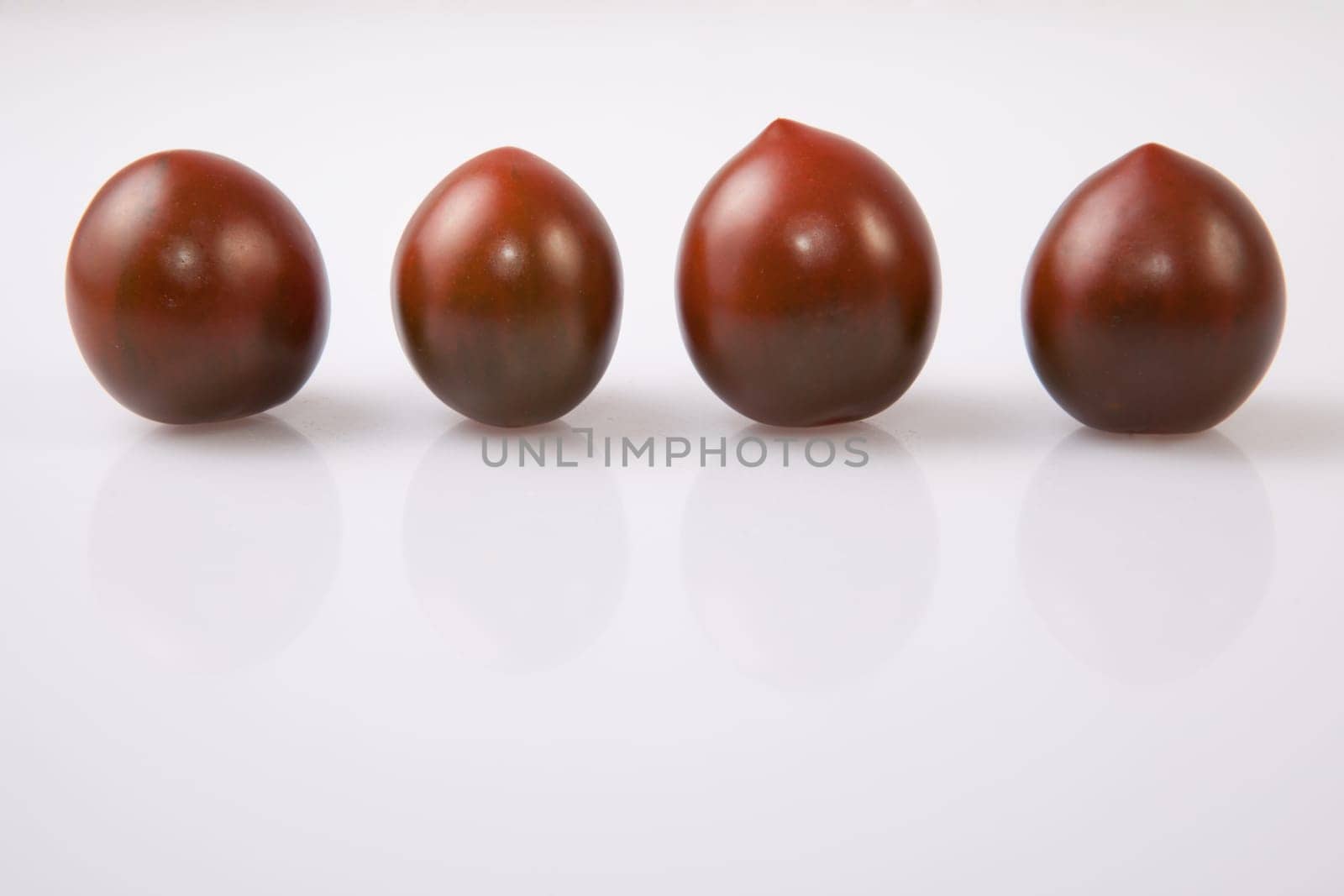 Dark green cherry tomatoes. Isolated over white background