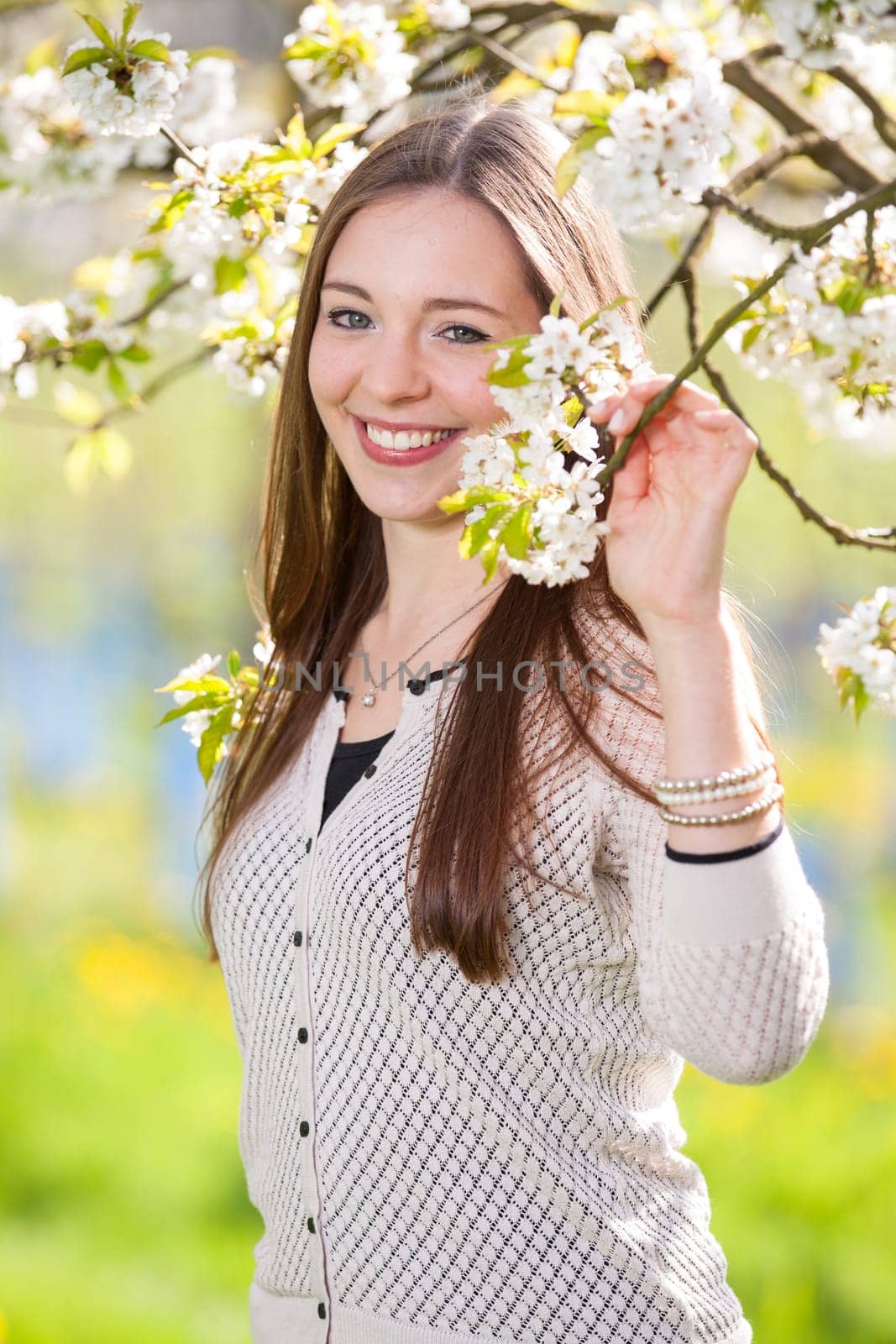 Young woman in spring amid cherry blossoms
