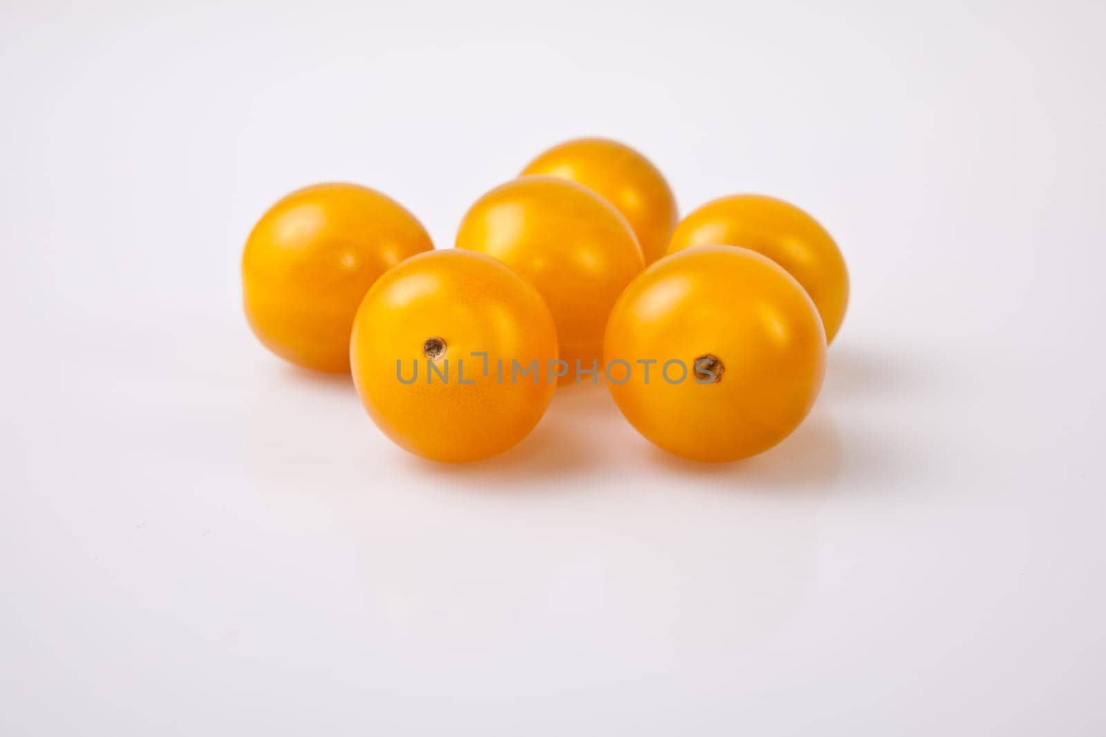 Yellow shiny cherry tomatoes. Isolated over white background