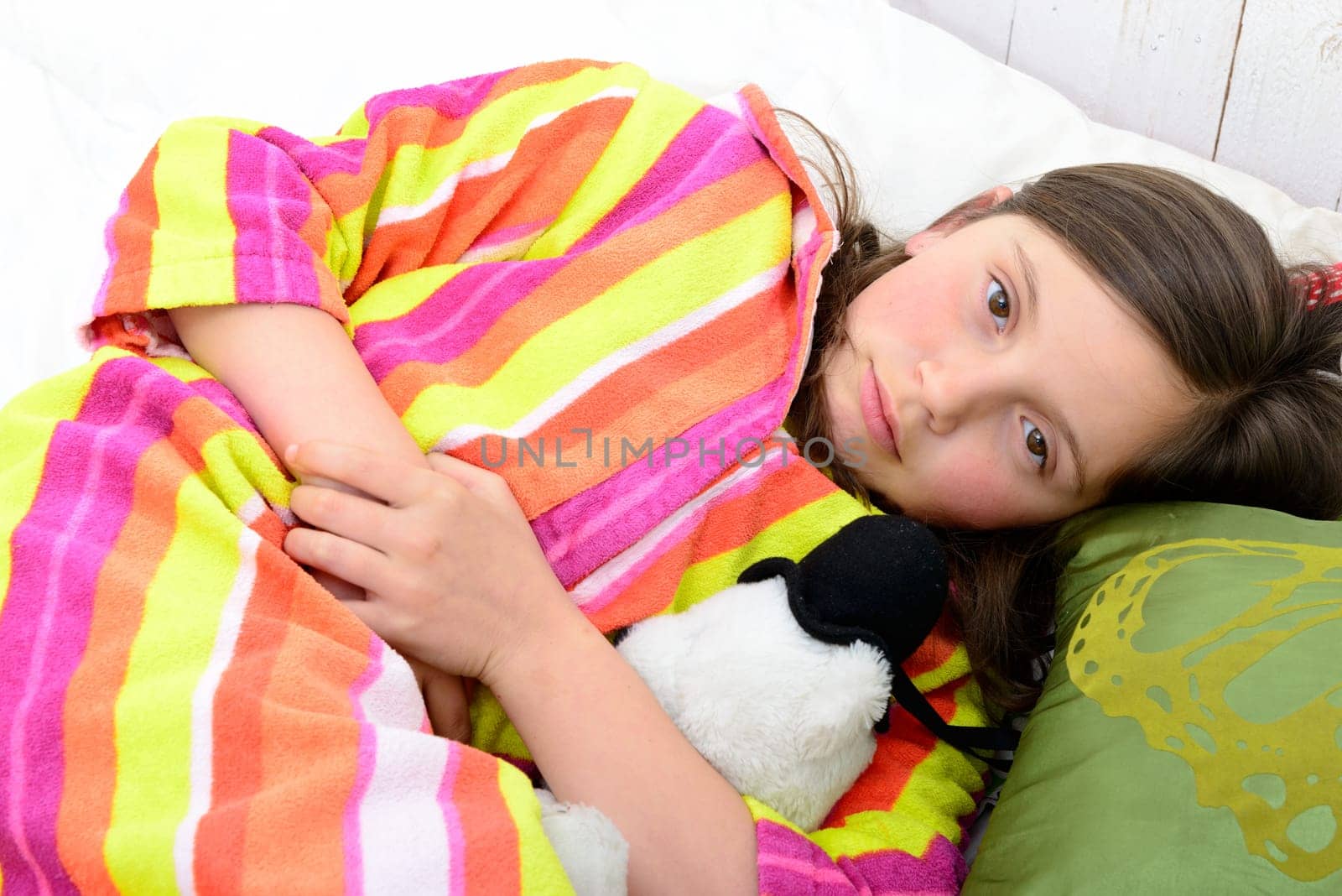 a little girl in her bed has a stomachache
