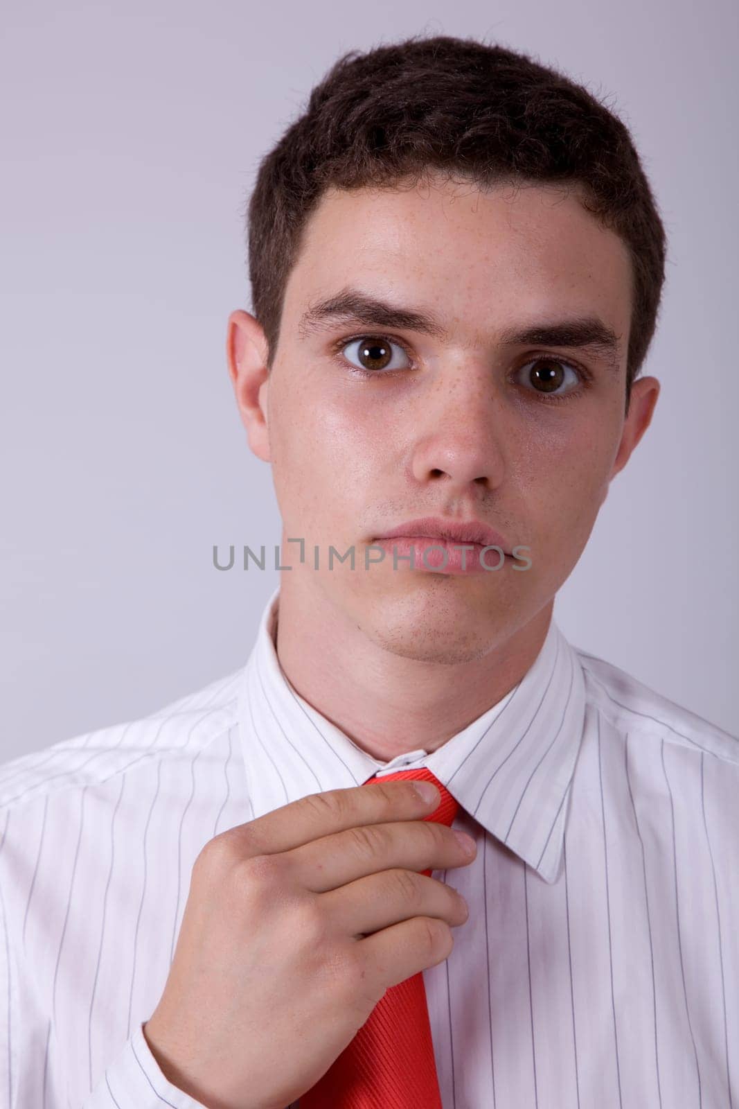 young business man pensive, adjusting his tie