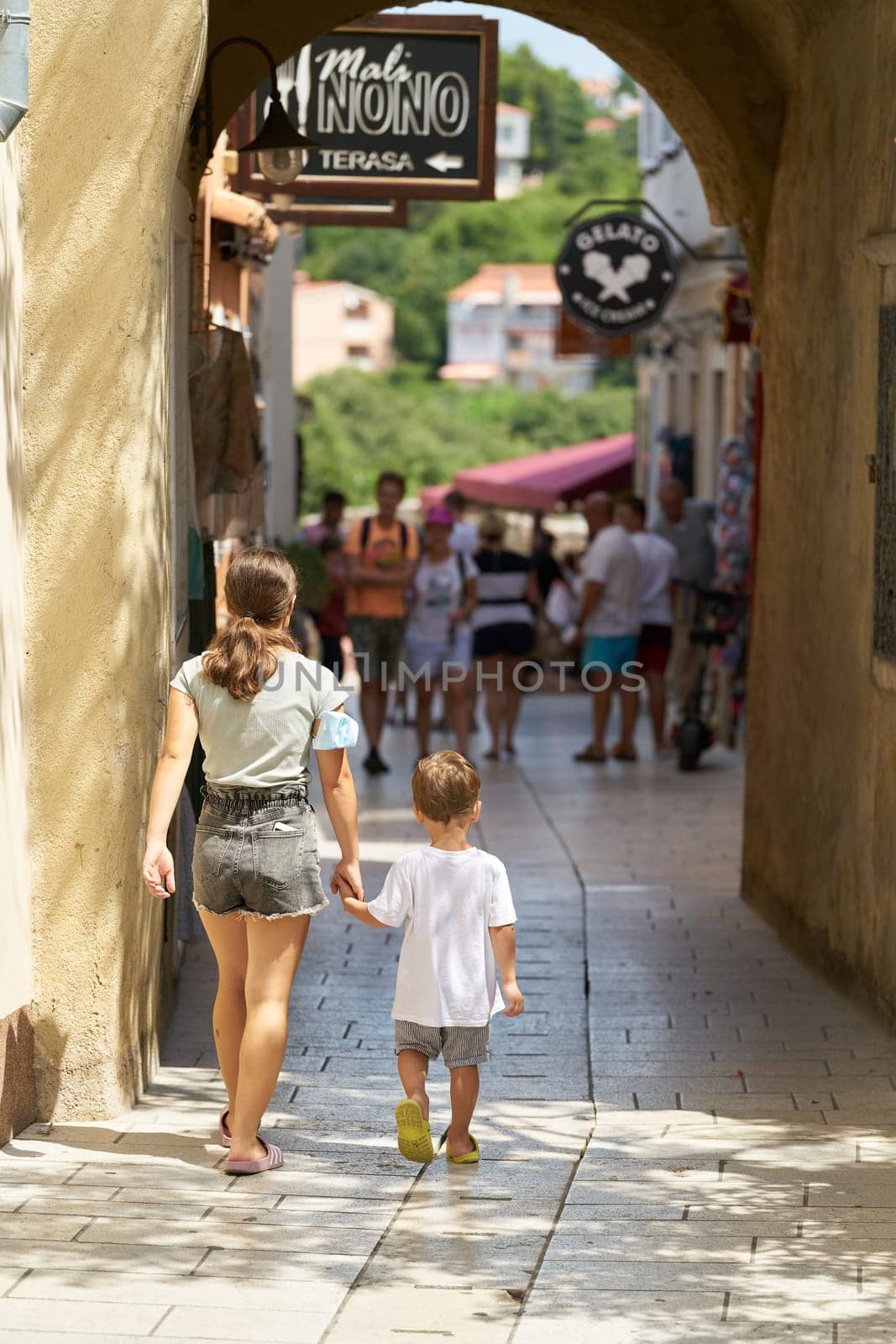 Holidaymakers in an alley in the historic old town of Krk on the island of the same name in Croatia