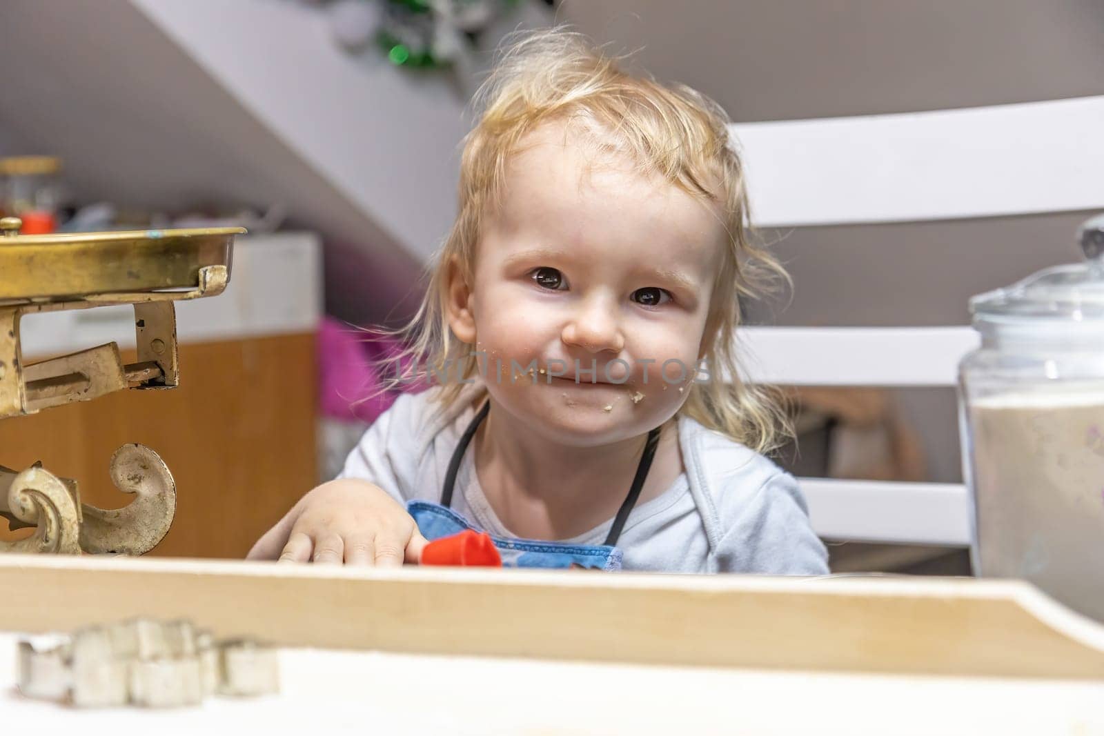 Little helper. Portrait of a cute boy with his mouth dirty from tasting cookies in the kitchen. Horizontally.