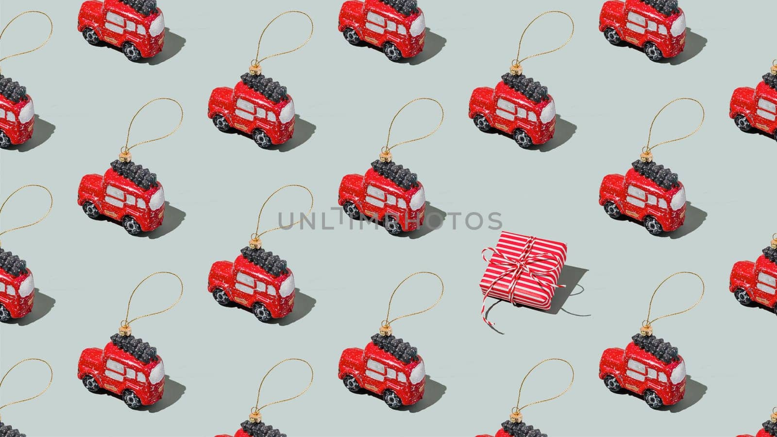 Gray green background pattern with Christmas, New Year symbol attribute objects and symbolic items concept. Small red English taxi car toy with ribbon, pink little gift box present. High quality photo