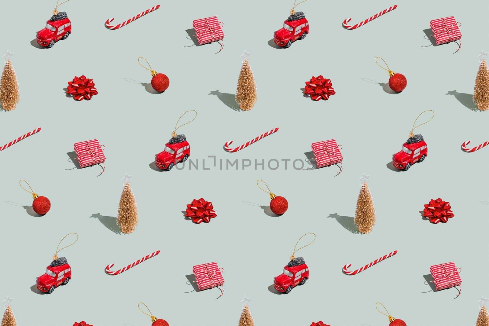 Gray green background pattern with Christmas, New Year symbol attribute objects and symbolic items concept. Small red English taxi car toy with ribbon, pink little gift box present. High quality photo