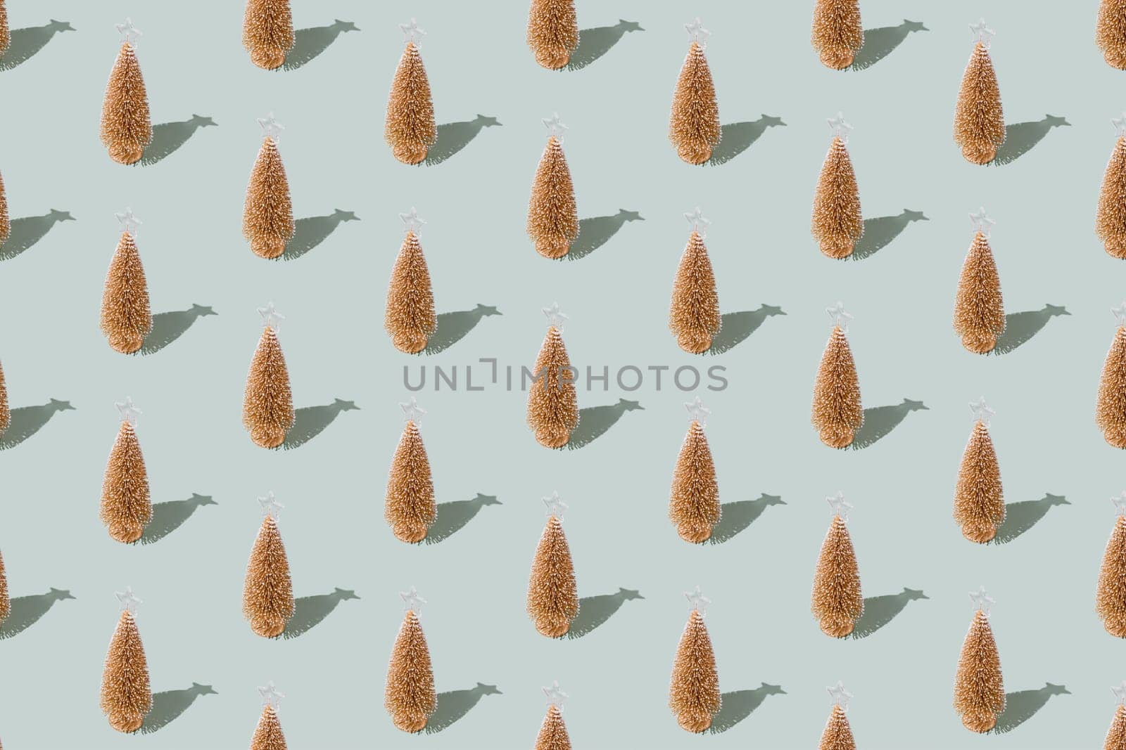Gray green background pattern with Christmas or New Year symbol attribute objects and symbolic items concept. Golden little toy fir tree with shadow. High quality photo