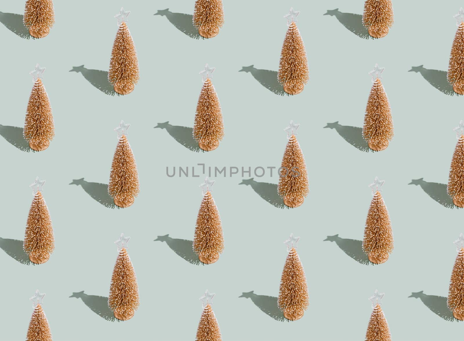 Gray green background pattern with Christmas or New Year symbol attribute objects and symbolic items concept. Golden little toy fir tree with shadow. High quality photo