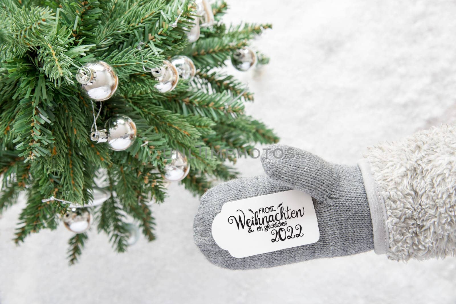Glove With Label With German Calligraphy Frohe Weihnachten Und Ein Glueckliches 2022 Means Merry Christmas And Happy 2022. Christmas Tree With Silver Ball Ornament And Snow
