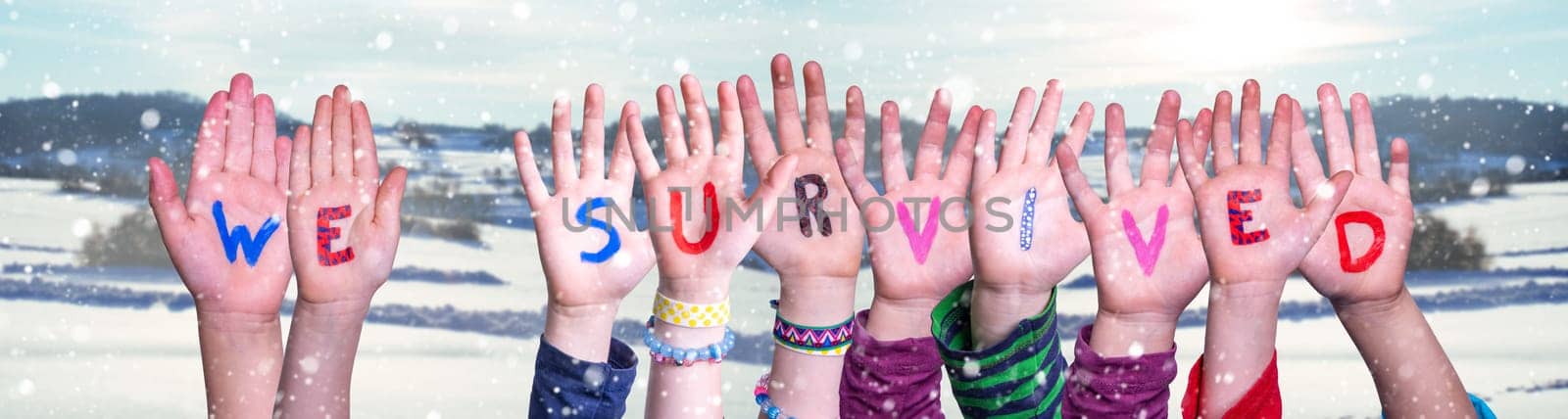 Kids Hands Holding Colorful English Word We Survived. Snowy Winter Background With Snowflakes