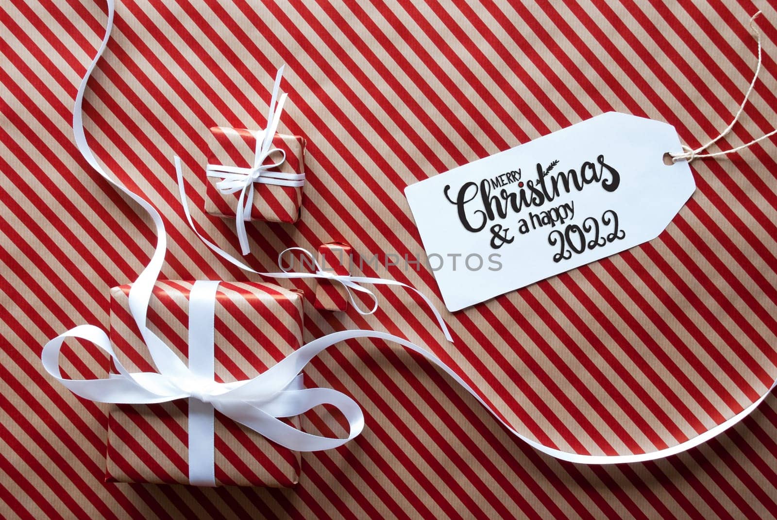 Label With English Text Merry Christmas And Happy 2022. Gifts And Presents On Red And White Wrapping Paper