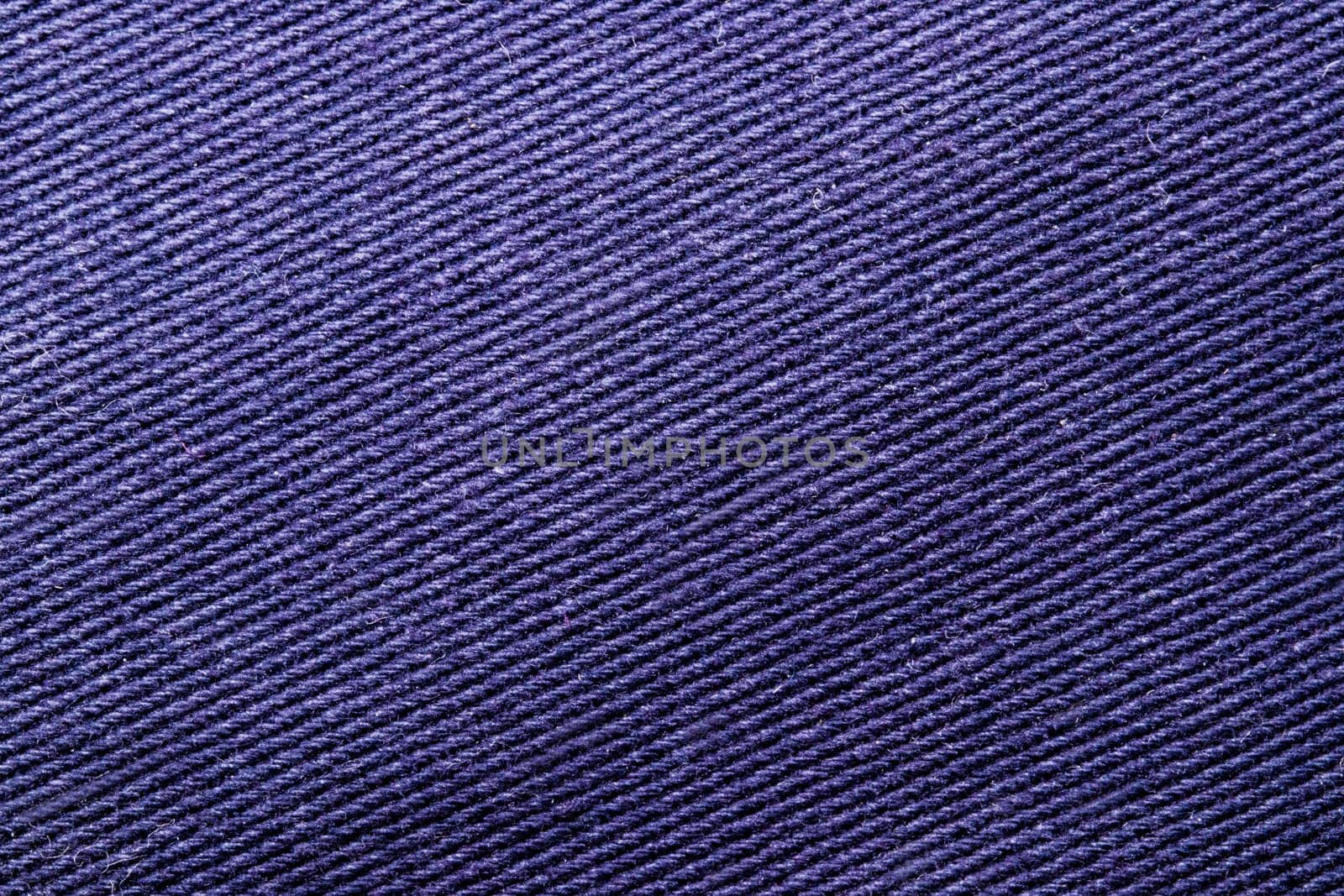 Violet fabric texture. Close-up of a purple seamless pattern for textile, bags or other garments. Macro.