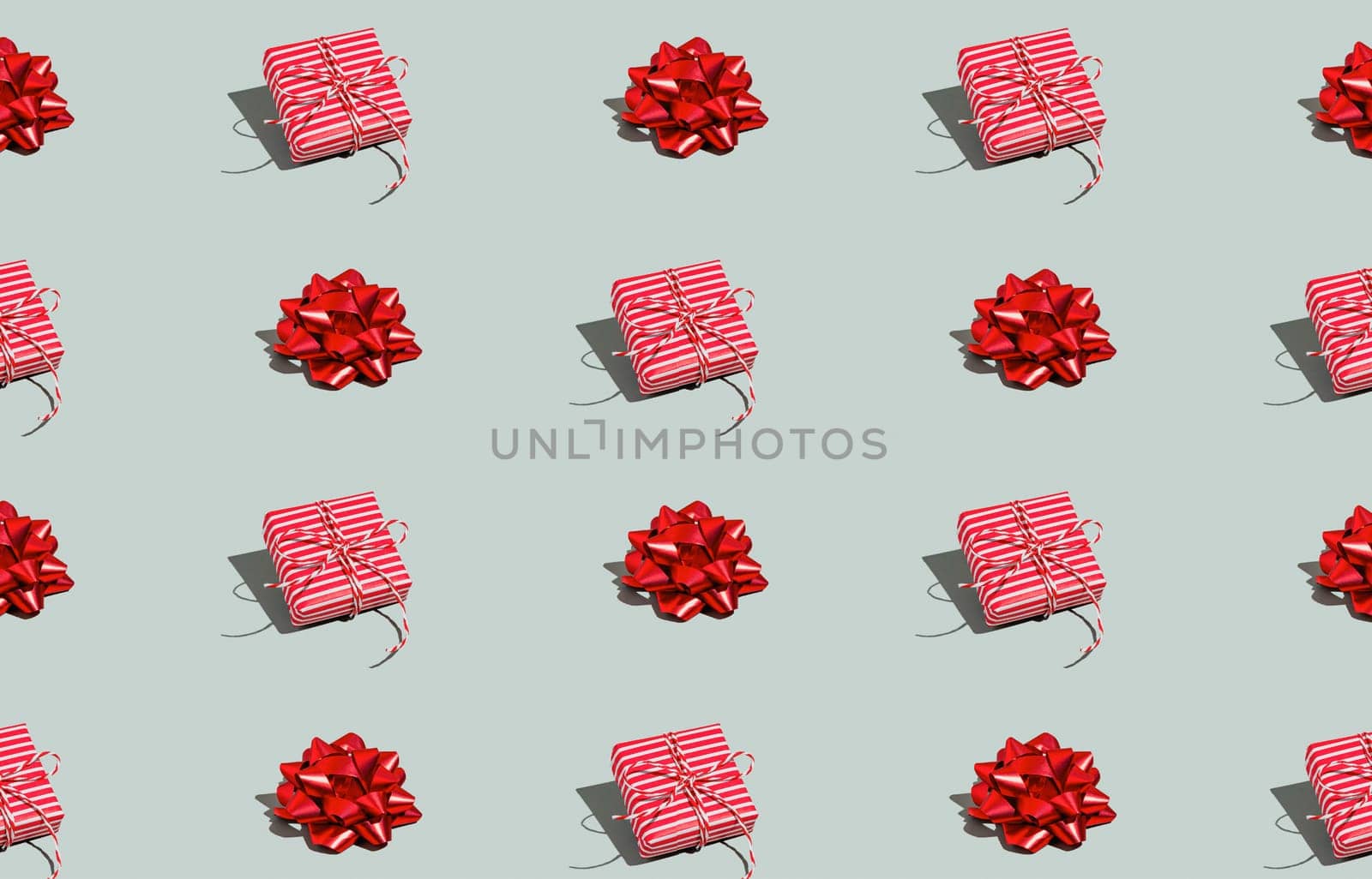 Gray green background pattern with Christmas, New Year symbol attribute objects and symbolic items concept. Pink little gift box present with ribbon, small red tied bow. Book cover, covering paper