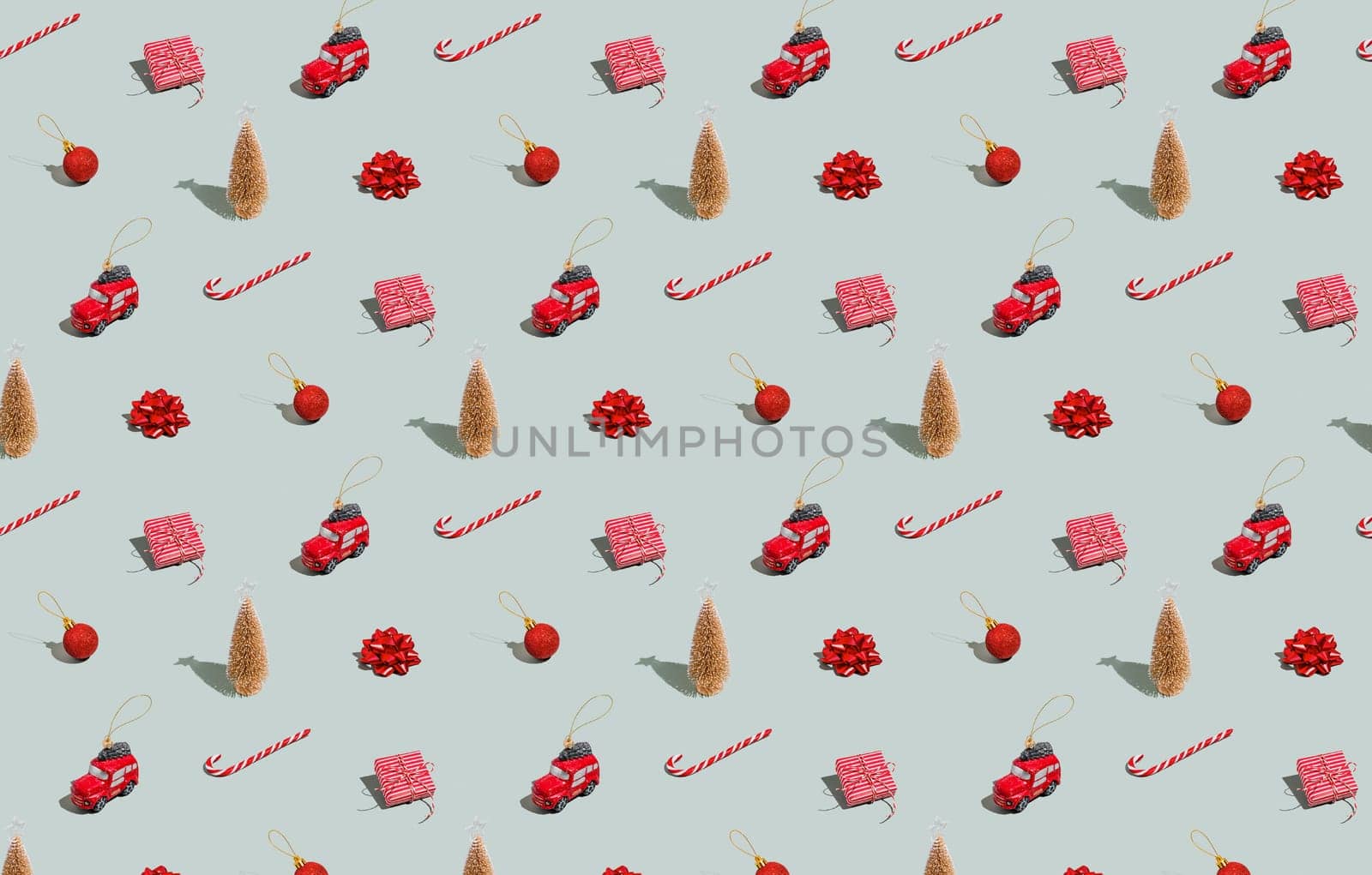 Gray green background pattern with Christmas, New Year symbol attribute objects and symbolic items concept. Small red taxi car toy, pink gift box present, lolli pop candy, lollypop, ball, fir tree