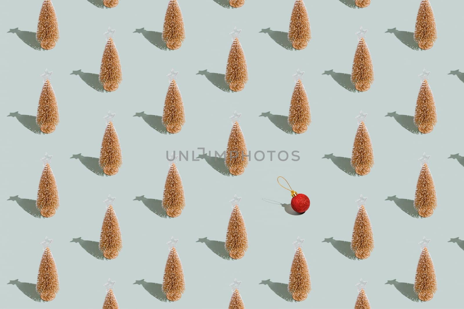 Gray green background pattern with Christmas or New Year symbol attribute objects and symbolic items concept. Golden little toy fir tree with shadow, red toy ball or sphere. Book cover, covering paper