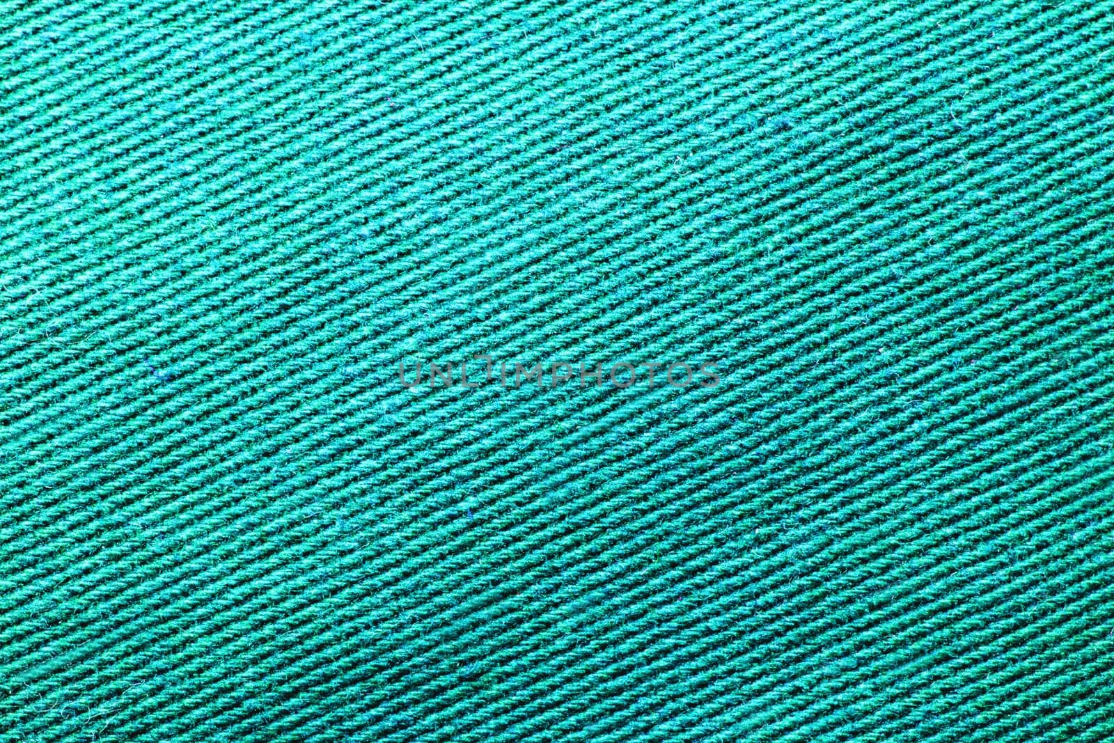 Green fabric texture. Close-up of a turquoise seamless pattern for textile, bags or other garments. Macro.