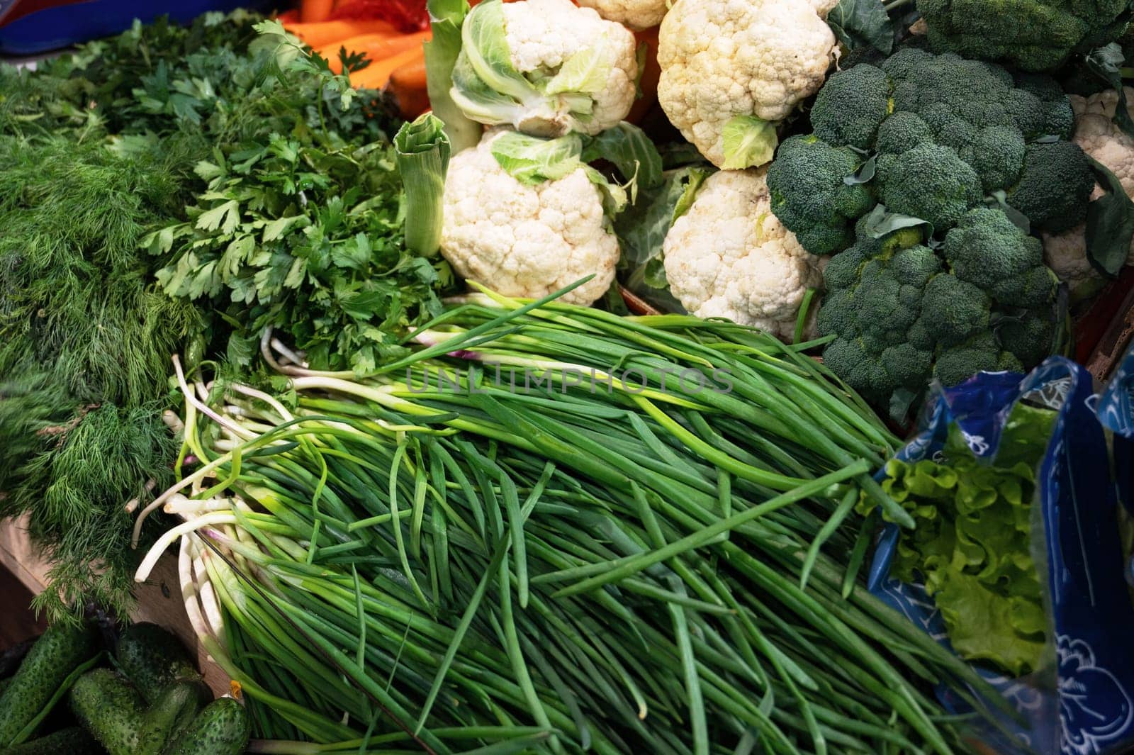 Green food background with assortment of fresh organic greens and vegetables at market