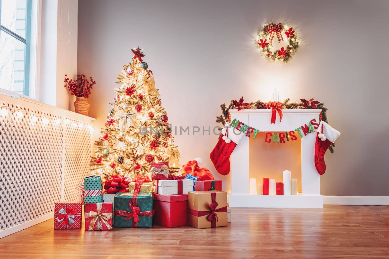 Christmas tree with gift boxes under it in the empty living room. Apartment in new year's eve with decorative fireplace and beautiful fir.