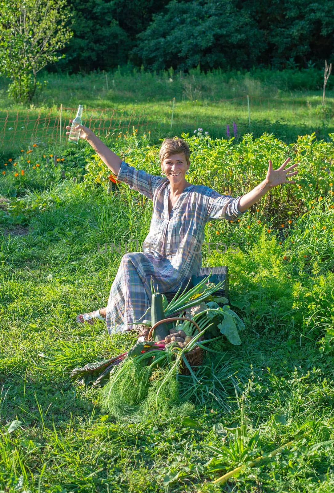 happy young woman with harvest in the garden