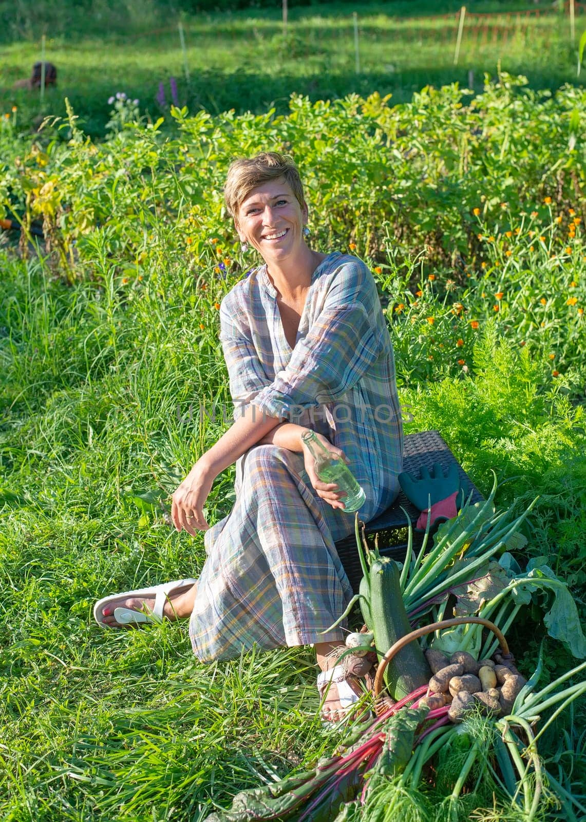 happy young woman with harvest in the garden