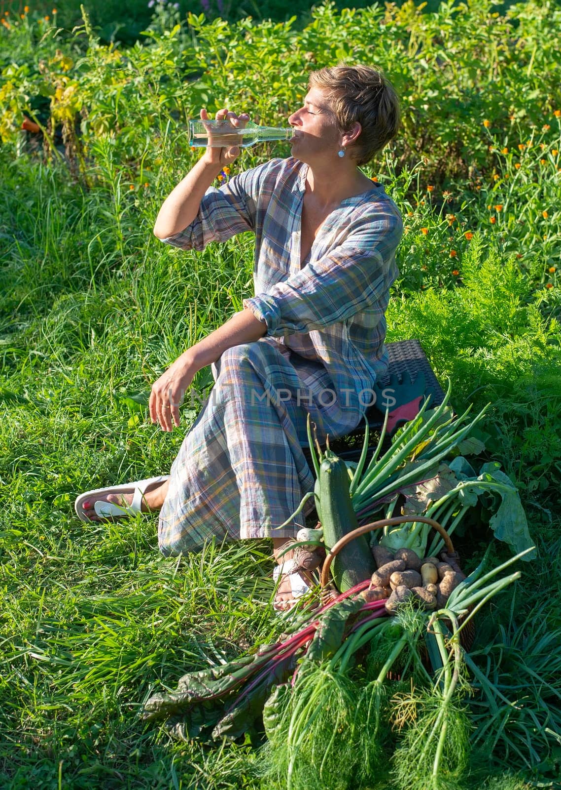 happy young woman with harvest in the garden