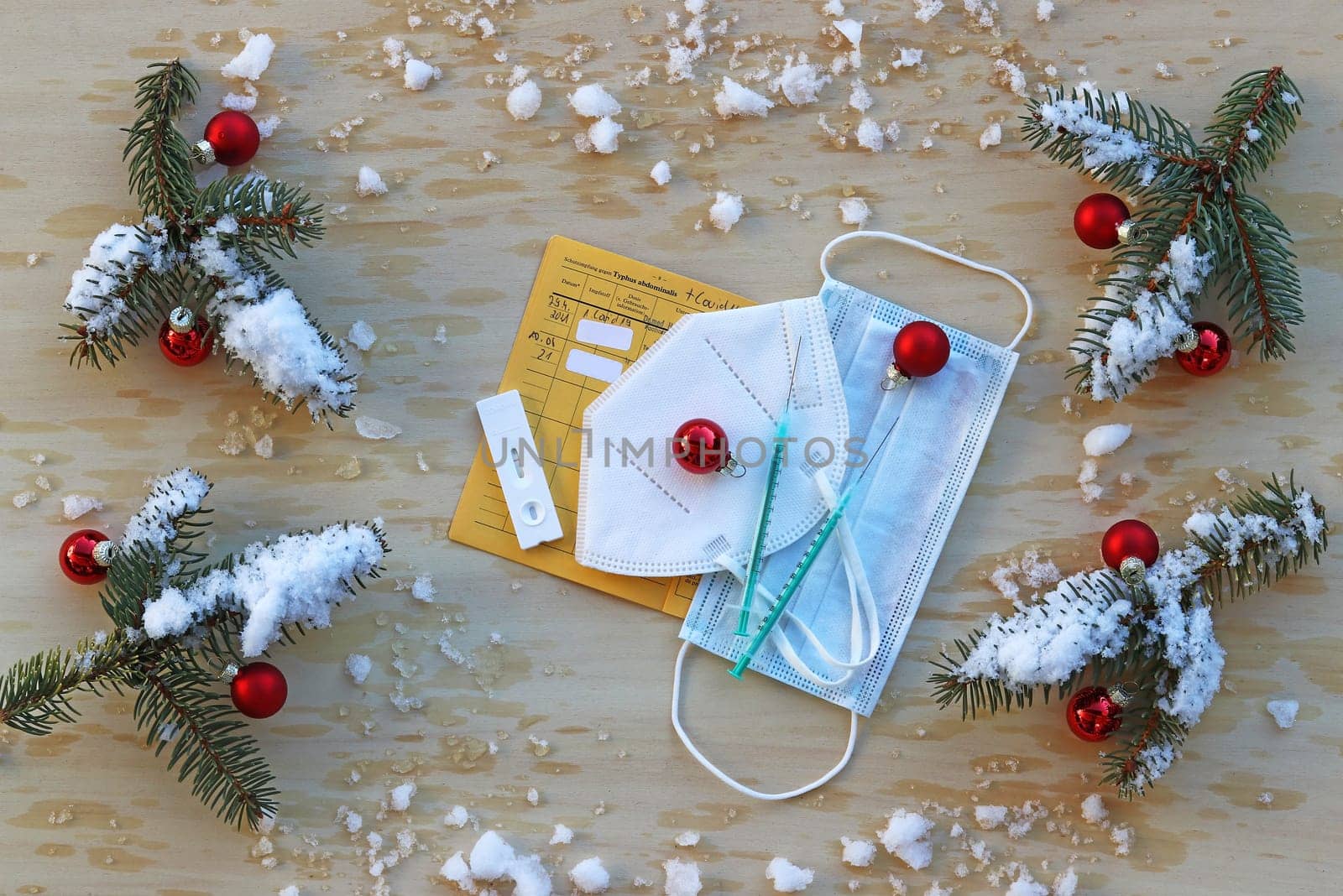 Corona rules at Christmas 3g, 2g or 2g plus. Masks, vaccination card, vaccinate, test with fir branches and Christmas tree balls on a wooden background