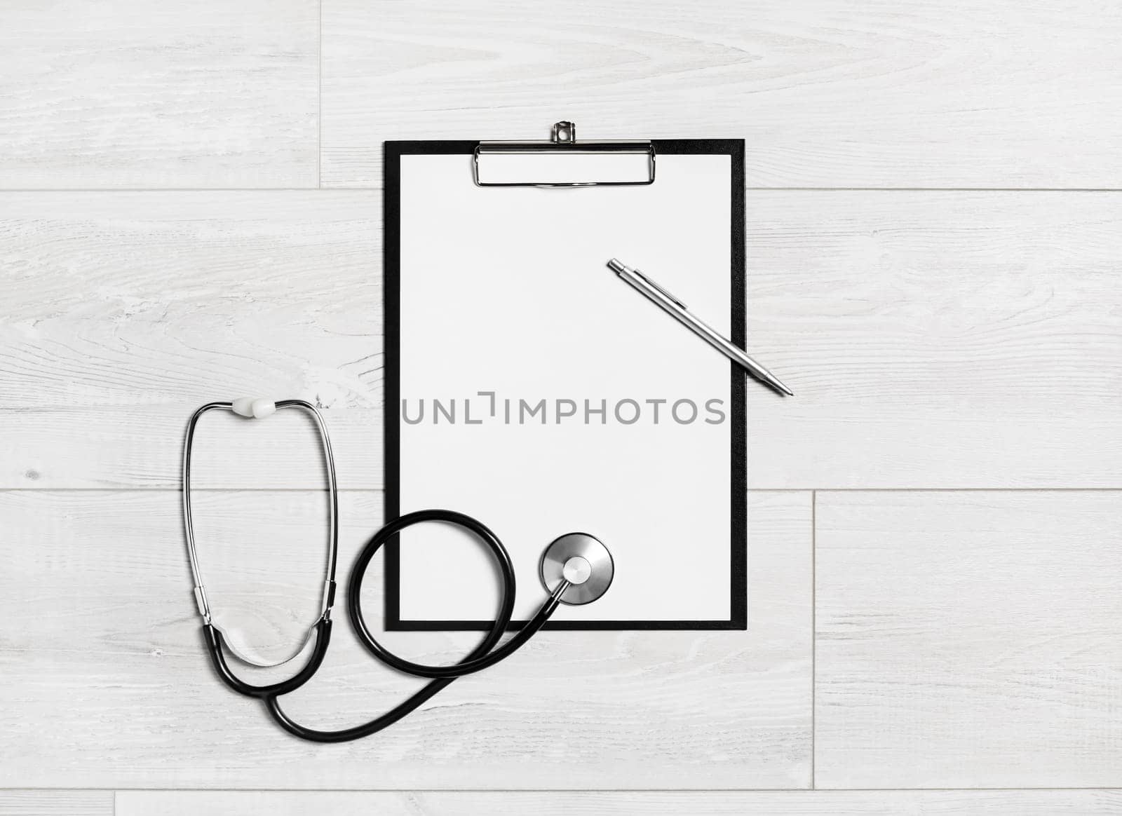 Photo of blank medical clipboard, stethoscope and pen on wooden background. Copy space. Flat lay.