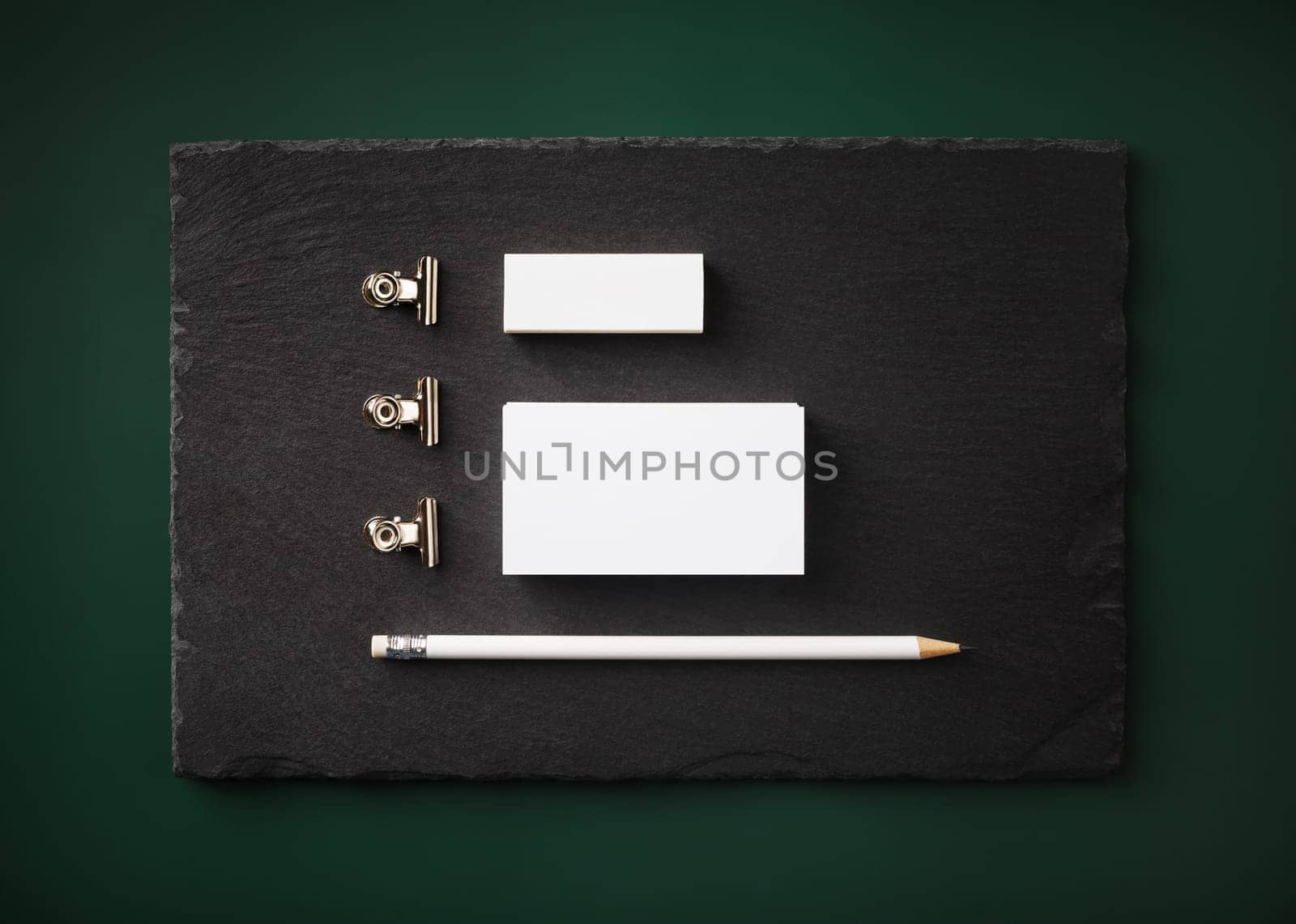 Photo of blank business cards, pencil, eraser and clips on stone board. Blank stationery template. Flat lay.