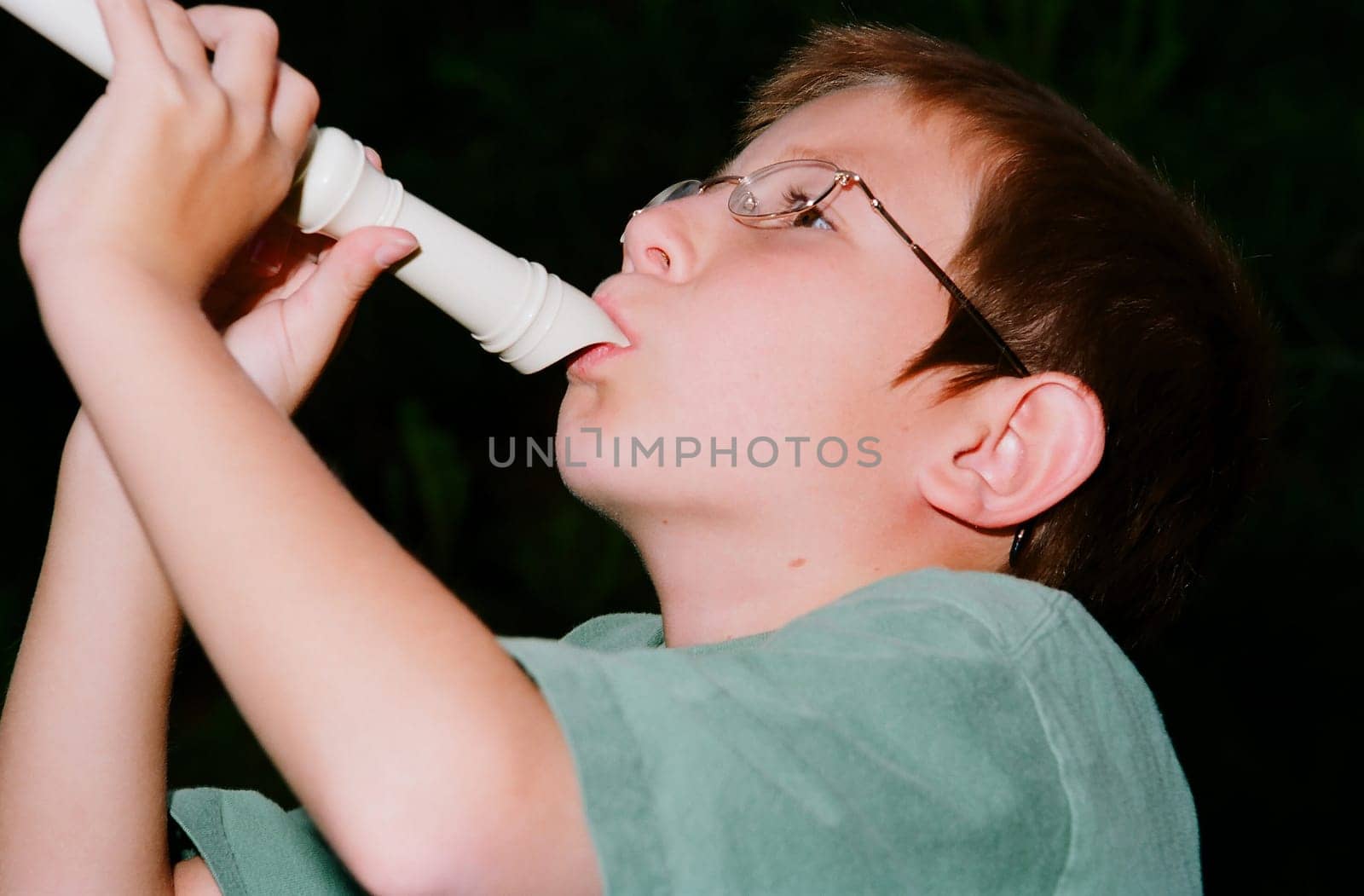 Young boy playing a recorder musical instrument