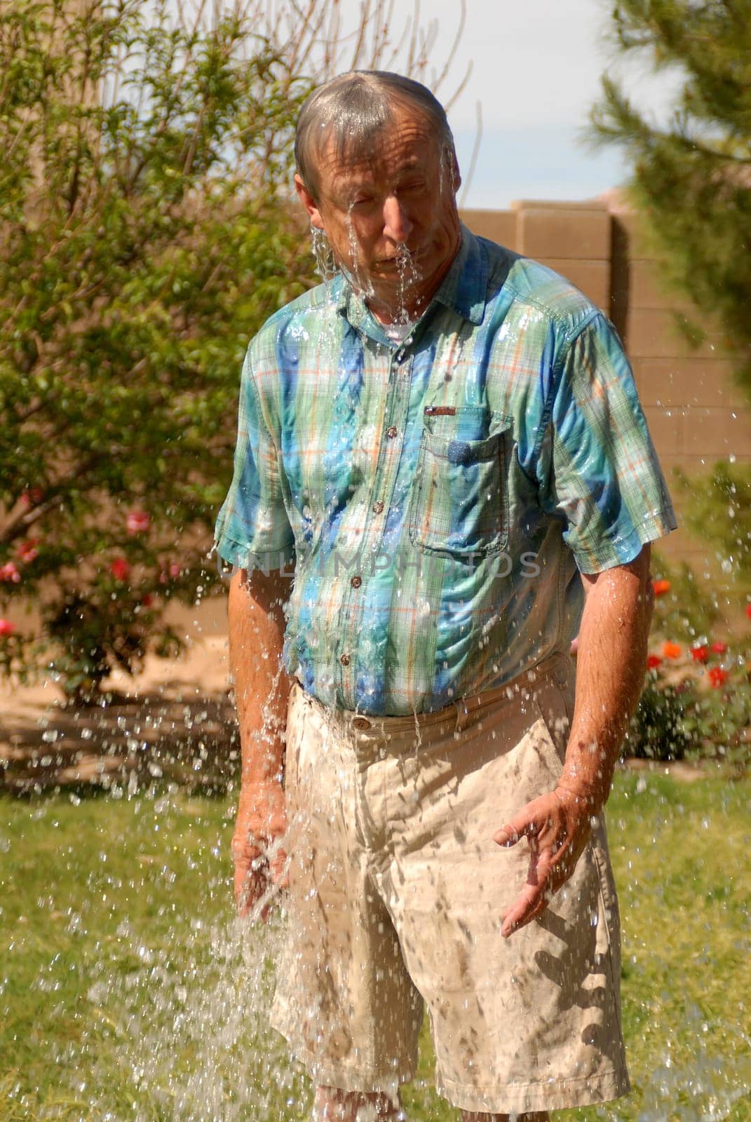 Senior man being splashed with a great deal of water