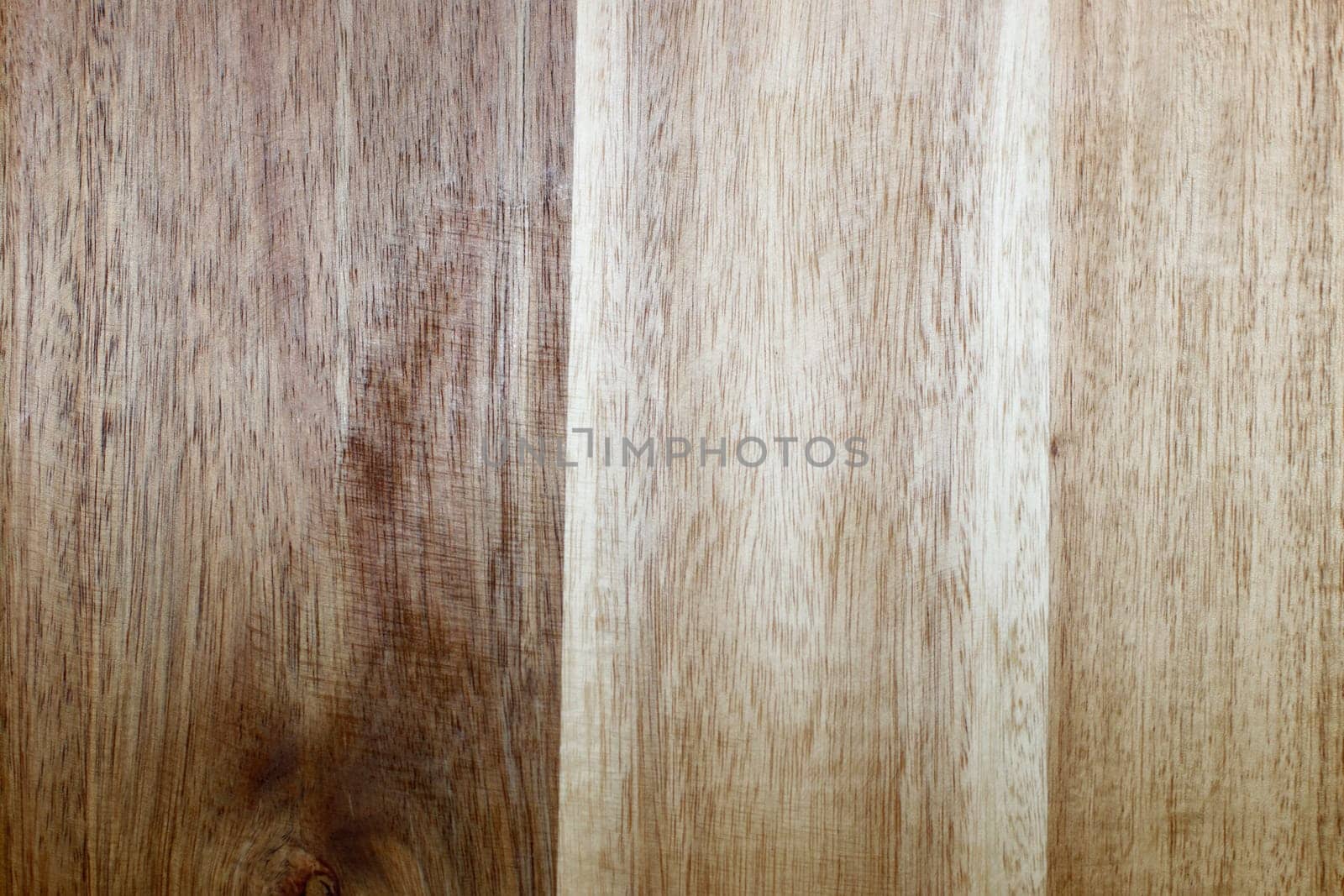 Background of brown and beige simulated wood grain vertical vinyl flooring planks closeup. Synthetic wood grain design planks brown and beige vertical vinyl flooring close-up of a flat background..