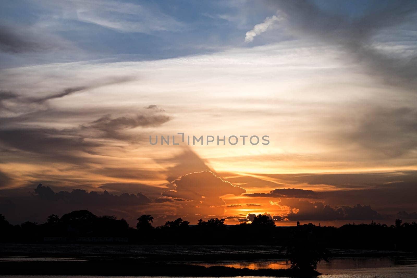 Giant dark cloud. Storm Clouds orange sky at Sunset nature landscape.