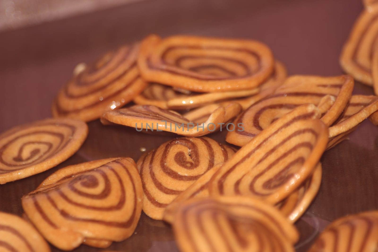 Closeup view with selective focus of a large number of round cookies with coconut filling lines.