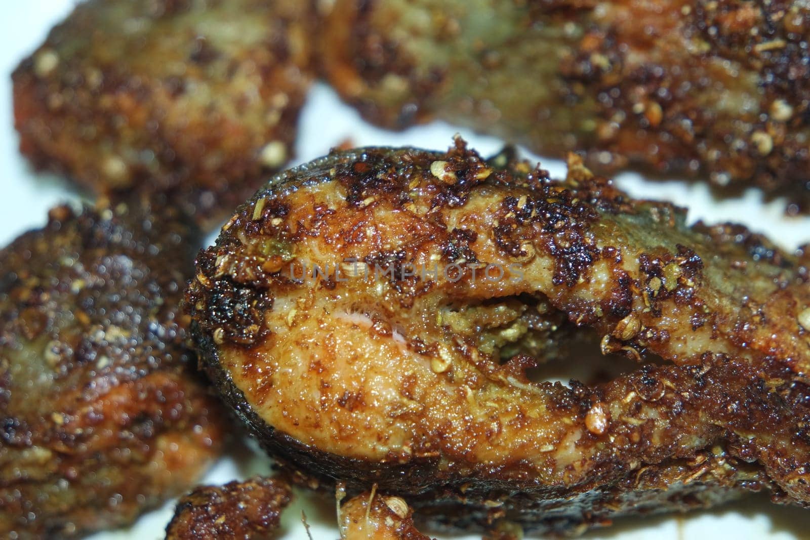 Spicy and crunchy barbecue of fried fish fillet on a white background. Homemade grilled trout fish steaks for health nourishments.