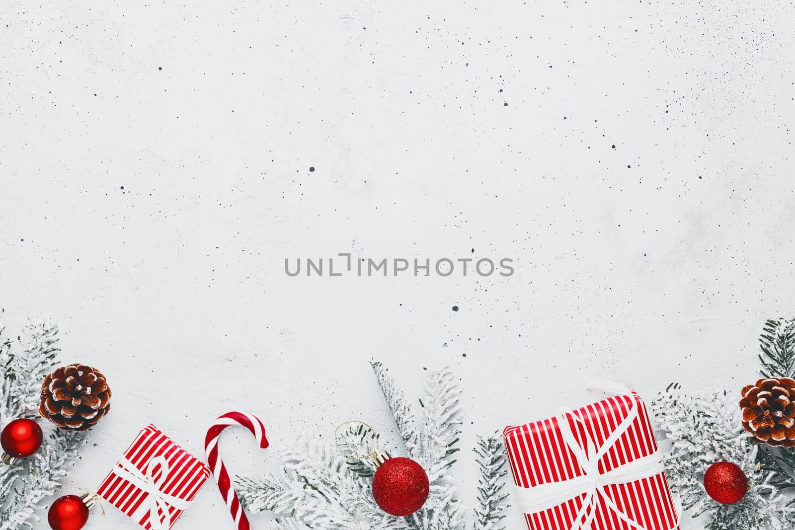 Christmas, New Year gray concrete flat lay with red white present gift boxes top view. Gift ribbon and packaging paper. Christmas tree fir, cones, toys, candy stick lolly, Copy space text area